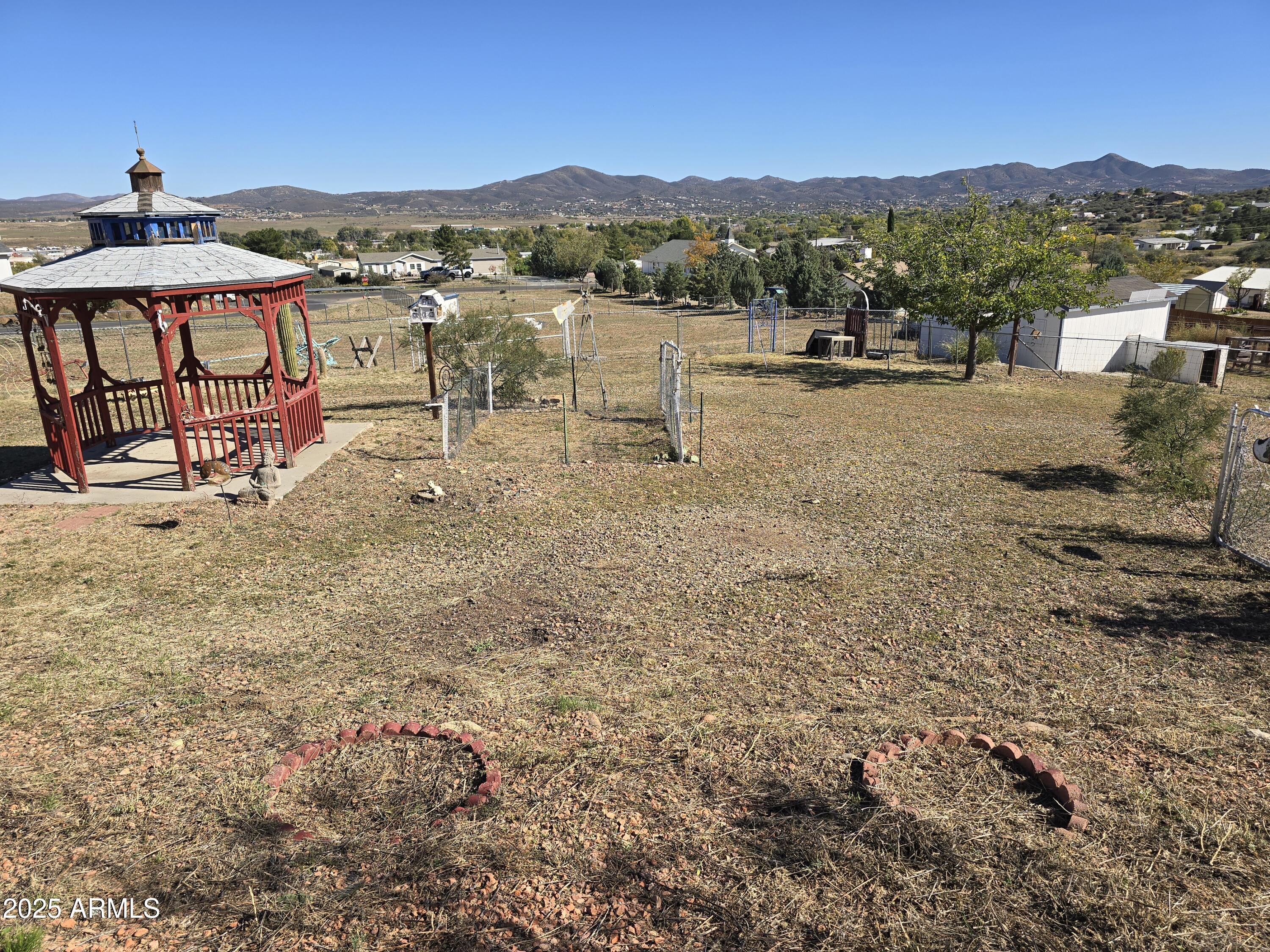 Great location. Wonderful panoramic mountain views. Corner horse property lot. Located less than one mile from Hwy 69. Ideal for horses or new home build. 3 bedrooms, 2 baths, double wide manufactured home with full length 400 Sq. Ft. add-on AZ Room with an attached 1 car garage, workshop and covered patio. Inside laundry room. W/D included. Located on a large 1.65 acre lot. Private well, 1,500 gallon water storage tank., above ground propane tank. Large extended 2 car garage - 23 ft by 23 ft. The entire property has perimeter fencing with cross pasture fencing. 3 large detached storage sheds & chicken coop. Newer roof in 2013 on home and attached garage.