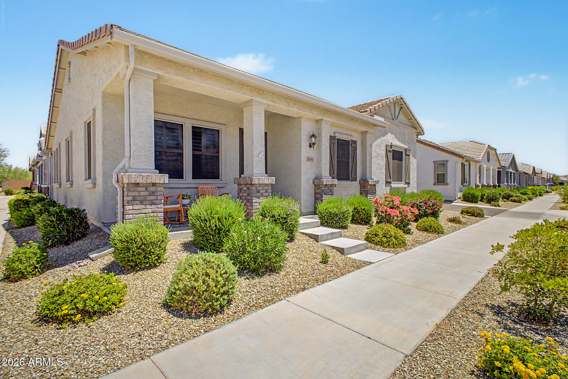 Fall in love with this charming home in the desirable Rancho Mercado community! Sits adjacent to a common area, offering 2 beds, 2 baths, and a side 2-car garage w/cabinets & epoxy flooring. The front porch is just the beginning! The inviting interior features tons of natural light, high ceilings, plantation shutters, neutral palette, and tile flooring in common areas. Large living room perfect for receiving guests! The eat-in kitchen boasts white cabinets, SS appliances, quartz counters, tile backsplash, recessed & pendant lights, a pantry, & an island w/breakfast bar. The main suite offers carpet floors & a private bathroom. Sliding glass doors open to the paver patio, providing easy indoor & outdoor living. Enjoy access to amenities such as a playground, pool, and park! Don't miss this!