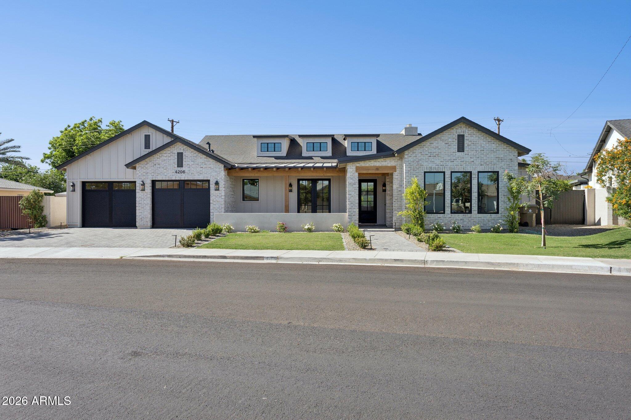 With its beautiful blend of painted brick, clean architectural lines, and modern farmhouse charm, this exceptional new construction home makes an immediate impression in the heart of Arcadia Osborn. Inside, the home unfolds with a thoughtful, highly livable floorplan designed for both everyday comfort and elevated entertaining. The kitchen anchors the main living space with an oversized island, Taj Mahal quartzite countertops, and custom cabinetry, creating a natural place to gather. A private office offers flexibility for work or study, while the dedicated dining room is ready for everything from intimate dinners to holiday celebrations. The primary suite feels like a true retreat, complete with a spa-inspired bath, a soaking tub, an oversized shower, and a generous walk-in closet. Each of the additional bedrooms is privately positioned away from the primary and features an ensuite bath, making the layout especially functional for family and guests. Outside, the backyard extends the living experience with a great patio and outdoor kitchen. Designed for both quiet evenings, easy entertaining, and the way families live today, this stunning new build comes together in one of Phoenix's most beloved neighborhoods. where new construction, charm, and location are rarely found in such balance.