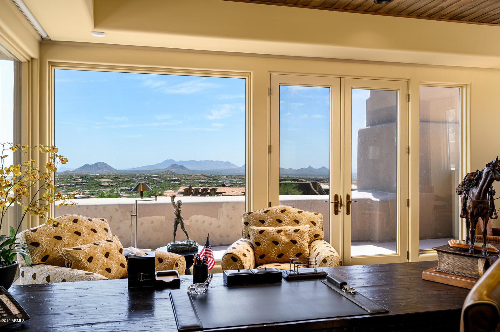 Amazing VIEWS from this Desert Contemporary home perched high in the Apache Peak Village in exclusive guard-gated community of Desert Mountain. This home exudes ''Welcome Home'' from the moment you step inside with striking views of the Valley of the Sun's magnificent sunsets and city lights. A 2nd floor addition, added in 2004, has elevator access, an impressive office/library with beautiful birds eye views, Full size Home Theater that comfortably seats 18 plus guests and includes a well-equipped kitchenette. Outdoor entertaining offers an Expansive 1,111 Sq.Ft patio with many areas for dining, sun bathing, enjoying conversations and TV viewing by a two-sided fireplace. A negative edge pool and spa that share a boulder waterfall feature are perfect accents to the sweeping views beyond