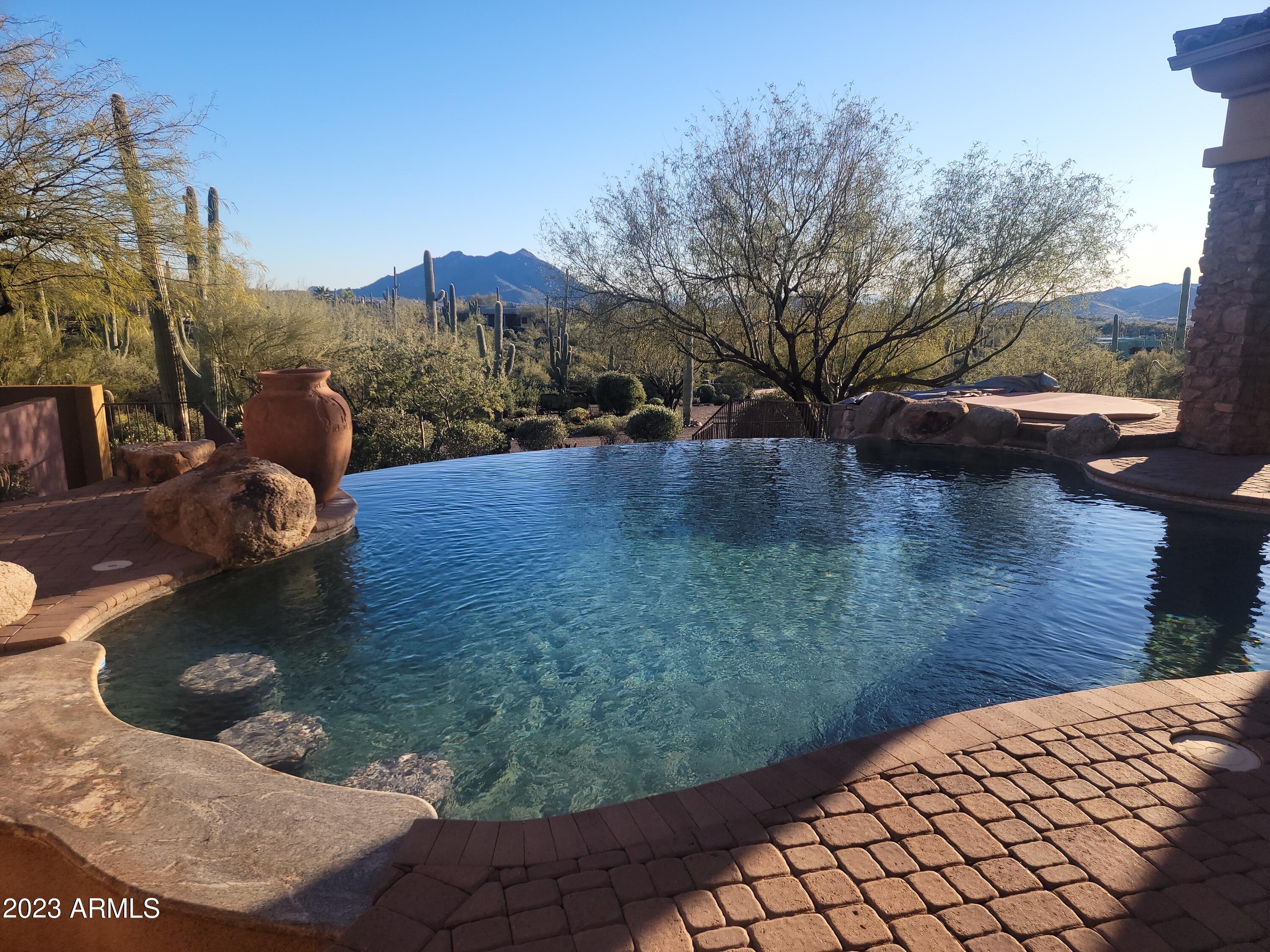 Secluded Mediterranean Custom Estate with Rock Entry and Electric Rod Iron Gates. Property is Only Minutes from the Historical Town of Cave Creek. This Magnificent Home is Located on 4.75 Acres of a Pristine Cactus Garden with Panoramic Views of Sunsets, Mountains and City Lights. Designed with 20 ft Wood Beam Ceilings, Floor to Ceiling Rock Fireplaces and Secluded Master Wing. Glass Doors Open to Your Outdoor Living Area with Negative Edge Pool and Massive Covered Patios. Entertain in a Walk In Wine Cellar, Majestic Winding Staircase to Library/Office with Wonderful  Observation Balcony. A Dream 1800 sq ft Garage with an RV Drive Through. Garage can Hold 6 to 7 Vehicles. There is a Separate Private Casita with Kitchenette. There is a 40 Yard Pitch and Putt Golf Area. A Dream Property!