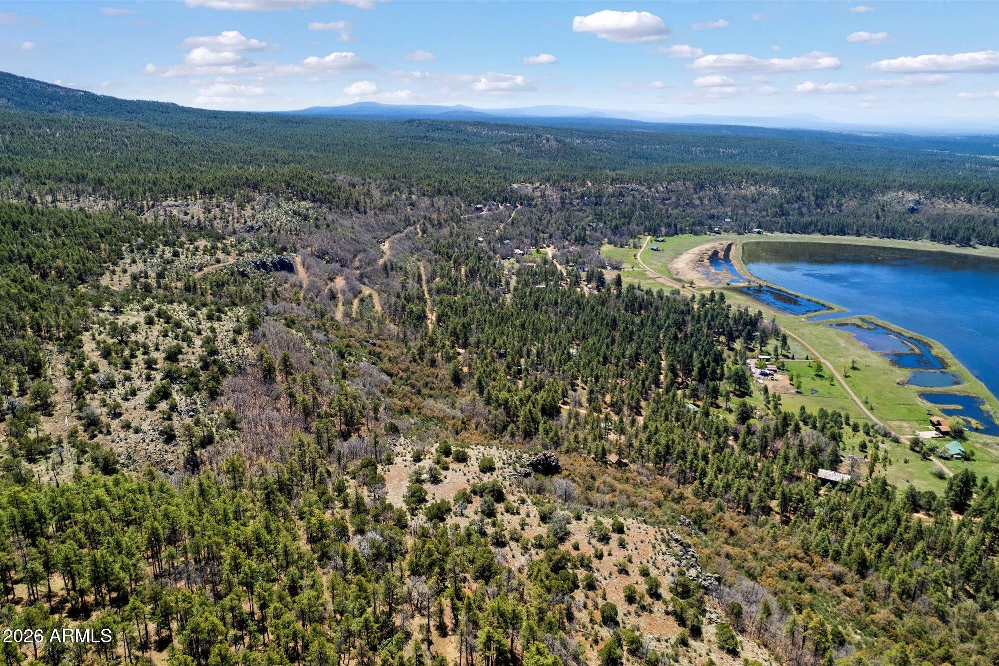 Perched high on the tranquil slopes of Stoneman Lake, this sprawling 24-acre parcel offers the ultimate escape with breathtaking vistas of the lush Verde Valley and the serene waters of Stoneman Lake below. This unique property invites endless possibilities, with multiple potential building sites for a personal retreat or development ventures. The land, densely populated with Ponderosa pines, features a hillside terrain that blends seamlessly into the surrounding natural beauty. Sitting at an elevation of 7,000 feet, this site offers a secluded atmosphere, perfect for those seeking peace away from the city's bustle