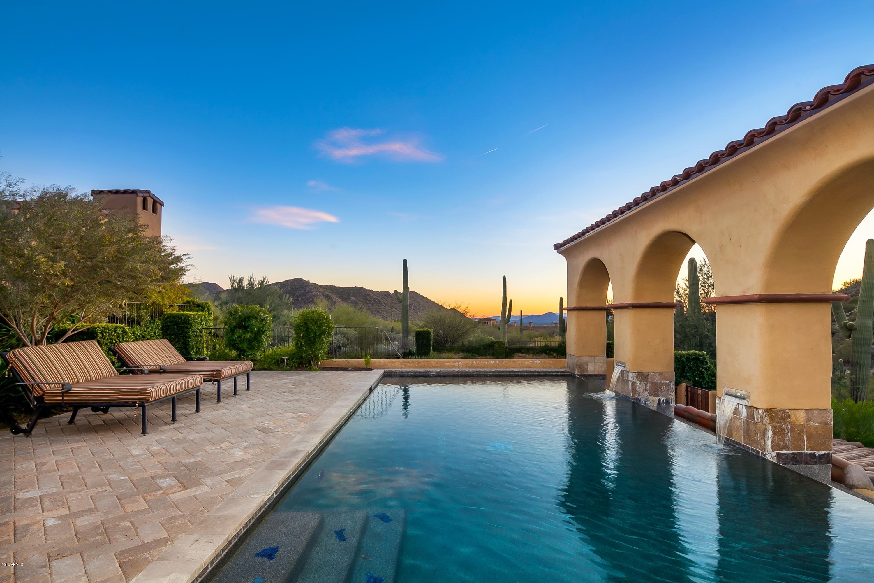 *See Features List in Documents* Spectacular estate in coveted community of the Upper Canyon at Silverleaf on EXCEPTIONAL 2-acre mountainside lot with mountain and city light VIEWS! Offering the best in privacy and desert living, this 4 br/4.5 ba Spanish Colonial-style home boasts hardwood floors throughout, pocket doors for truly indoor/outdoor living, wood-beamed ceilings, and several outdoor living spaces. The gourmet kitchen is a chef’s dream that includes a gas cooktop, stunning brick wall, spacious breakfast bar and island with vegetable sink, and can’t-miss granite counter tops. Formal dining room connects to kitchen via butler’s pantry, and the separate bright breakfast room has easy access to the outdoor living area. Home theater includes a large screen and HD projector and is perfectly positioned on the kitchen/formal dining room to entertain guests. Generous owner's suite is a light-filled retreat with private access to one of the many covered back patios. Spa-like en-suite owner's bath features dual vanities with plenty of storage space, a stunning soaking tub and separate shower, both with gorgeous tile accents, and a walk-in closet. Down the hall, two guest suites offer privacy with their own en-suite bathrooms. Upstairs, separate guest quarters include a full, en-suite bath, built-in storage, and balcony. You do not want to miss the backyard, which is a resplendent space complete with negative-edge pool facing the mountain, covered patio with wood-beamed ceilings, built-in BBQ, and outdoor fireplace, and a charming courtyard leading to a peaceful grassy area with city light views. This home is luxury living at its finest!