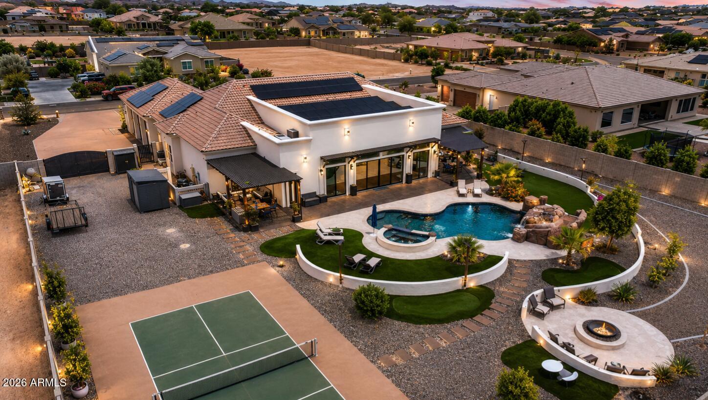Beautiful custom Waddell estate offering over 5,000 SF with 4 bedrooms, 4.5 bathrooms, plus a full outdoor pool bath perfect for entertaining. One of the dual studies features a Murphy bed and could easily serve as a 5th bedroom. This split floorplan offers oversized bedrooms, expansive great room, chef's kitchen with large island and walk-in pantry, and a luxurious primary suite with spa-style bath and oversized closet. Backyard retreat includes a stunning pool with slide, pickleball court, RV parking, chicken coop, and plenty of entertaining space. Paid-off solar adds efficiency and savings!
