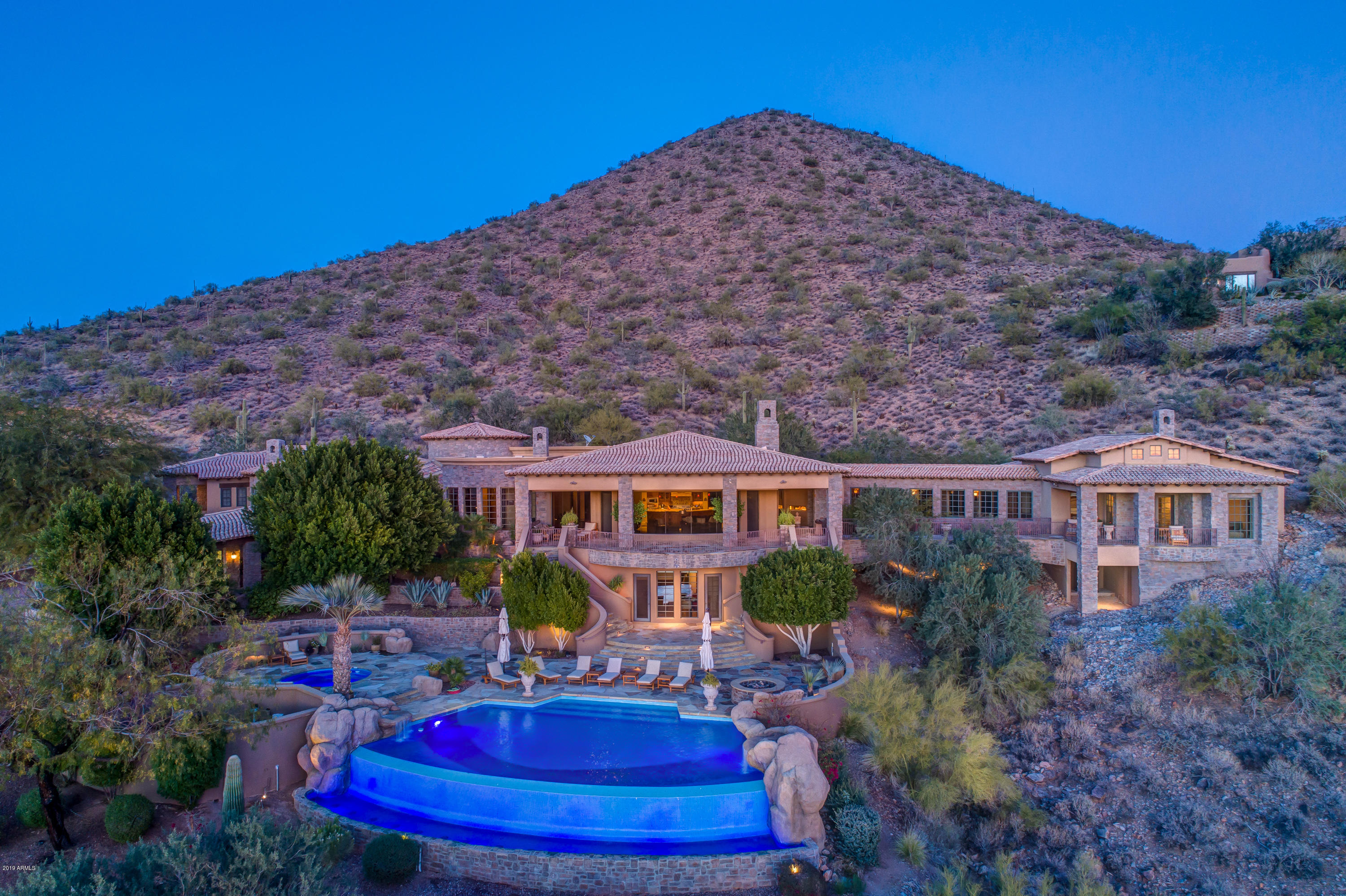 Your very own hilltop estate. Boasting over 10,000 amazing Sq/Ft of luxury. Perched
mountainside on OVER 13 ACRES, this fabulous masterpiece is architecturally stunning. 360 degrees of breathtaking views. Located in the posh gated community of Canyon Heights. This majestic home defines luxury. Featuring lavish amenities including top of the line appliances, library, home theatre, butlers pantry, two laundry rooms, elevator, soaring ceilings attached guest suite, negative edge pool, oversized spa and separate 1,350 SqFt guest house. Imagine crossing over a desert wash via a suspended window lined walkway to enter the luxurious master suite complete w/exercise room, sauna, jetted tub, his & hers water closets w/ bidet, & much more!Private security gate at both entrance of community and home