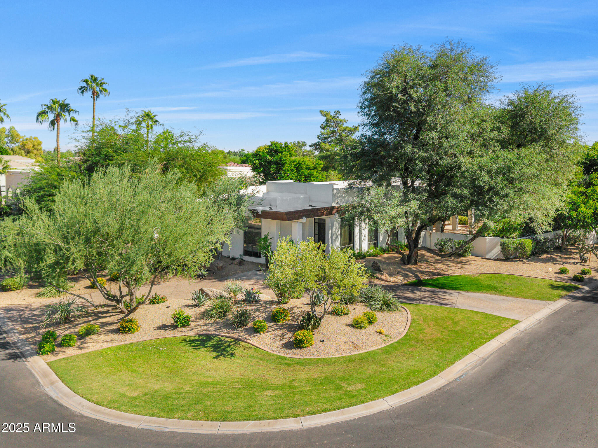 Welcome to the esteemed gated community of Merrill Cantatierra in the heart of Paradise Valley. This home will draw you in from the moment you step inside with a desirable open floor-plan featuring high ceilings, an oversized great room, living room, wet bar, formal dining, formal office/library and a chef's kitchen. With stunning new wood floors throughout, and two show stopping stone fireplaces, this sophisticated, modern home is perfect for everyone. The updated kitchen boasts a gorgeous quartz waterfall island, new appliances and fantastic views out to the private resort style backyard. This primary suite is the star of the show with the spa-like bathroom that invites you in. The private backyard embodies superb resort living with the following amenities- putting green, tranquil pool, spa, gas fire pit and an outdoor kitchen. Perfect for indoor/outdoor living. The exquisite design, coupled with premier quality and finishes, have created an exceptionally elegant home. Don't miss out on this one!