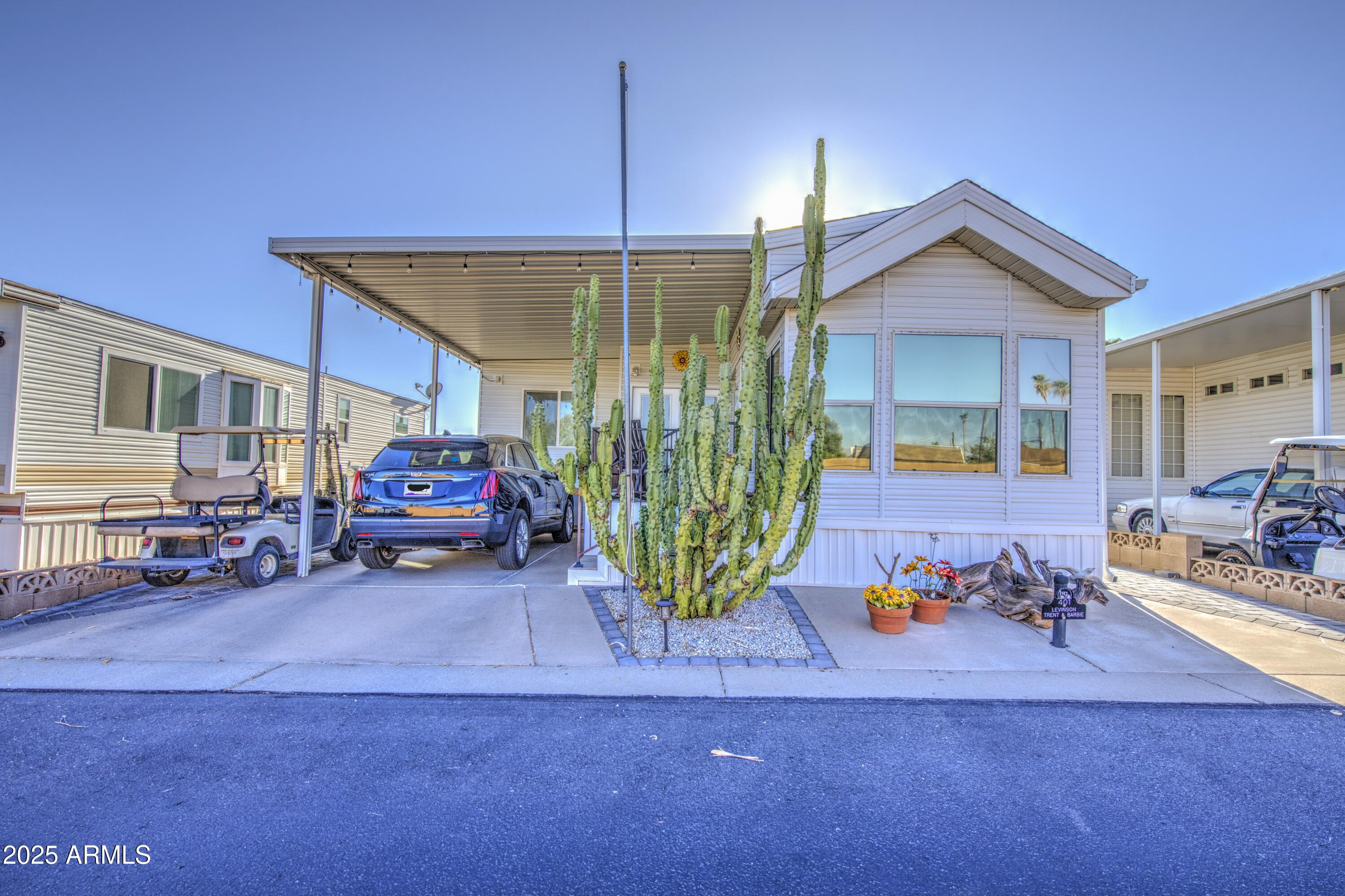 This 2002 Park Model with AZ room built in 2020 is in a great location in Carriage Manor Resort, a premier 55+ Community where you OWN THE LAND! Enjoy the sun come up over the Superstition Mtns on your tiled deck with powder coated rails and not having anyone across the street. You'll also enjoy pavers all around the home so no worries about weeds. Inside you'll find BRAND NEW kitchen cabinets, counters, sink and flooring with updated stainless steel appliances as well as reverse osmosis. Most of the windows are dual pane and this home comes with 2 hot water tanks, 20gal & 30gal, and dual ducts for the A/C & heat. The bedroom has a king size bed. The main bathroom has a tub while the 2nd bath in the AZ room has a walk-in shower and separate full size washer & dryer. Carriage Manor has 24/ on site security, a heated saltwater pool/spa, fitness facility, Tennis, Pickle ball, Golf Club, Onsite heated pool/spa, nice fitness facility, Tennis, Pickle ball, Golf Club, Billiards, Lapidary/Silversmith, Sewing, Wood shop, Bingo, Dances parties & many more activities & amenities.