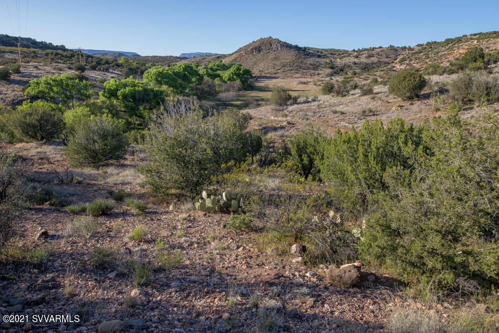Acreage and Privacy!  131 Acres surrounded by Forest Service and State Trust Land.  Includes over 1/2 mile of Spring Creek, a year-round stream, and irrigation rights for 31-acre-feet over 17 acres.  Pristine hidden property includes creekside greenbelt, meadows, cultivable acreage, mesas and hillsides.  Also existing are 3 old occupied residences (not warranted) of 720 SF built in 1944, 1200 SF built in 1944, and 1876 SF built in 1954 plus a barn of 3321 SF built in 1944, and a quonset hut (that could be removed).  Well exists for domestic use.  Road Easement across State Trust Land to convey with sale.  Unusual and unique offering.  Farm/ranch, grapes/etc, sustainable living, private enclave, or subdivision - endless possibilities!