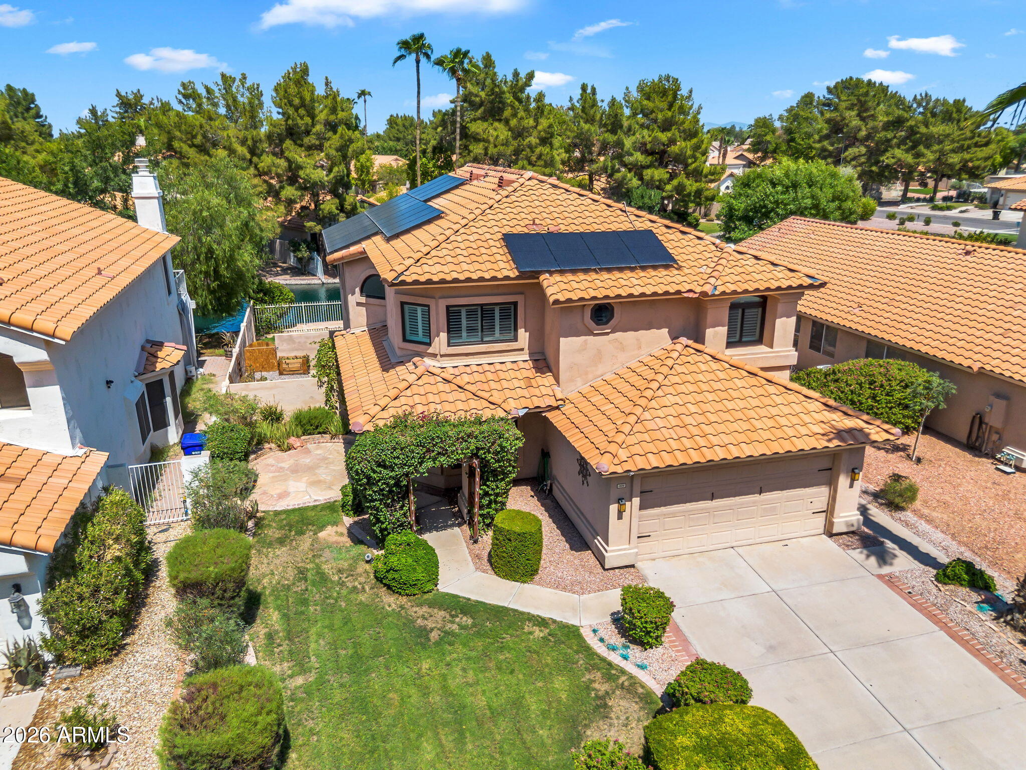 Welcome to this stunning lakefront home in the sought-after Pecos Ranch community! This beautifully maintained property features fully owned energy-efficient solar panels and all new Anderson windows, ceiling fans, flooring, interior paint, baseboards, refrigerator, and a sliding door in the primary bedroom. Plantation shutters are installed throughout, including on all upstairs windows. Enjoy a flexible layout with a formal dining room and a spacious great room that opens to the backyard--complete with a grassy play area and serene waterfront views. The elegant kitchen boasts stainless steel appliances, Corian countertops, mosaic tile backsplash, a center island, and abundant white cabinetry with crown molding. The sunny breakfast nook with bay window adds extra charm. Upstairs, the primary suite offers lake views, a walk-in closet, and a private bath with dual sinks. The backyard is perfect for relaxing or entertaining with a covered patio, play space, and a navel orange tree. Additional upgrades include a new sprinkler and drip system, Night Owl security system, Ring camera, and Nest thermostats. Community pool and tennis courts are just down the street.