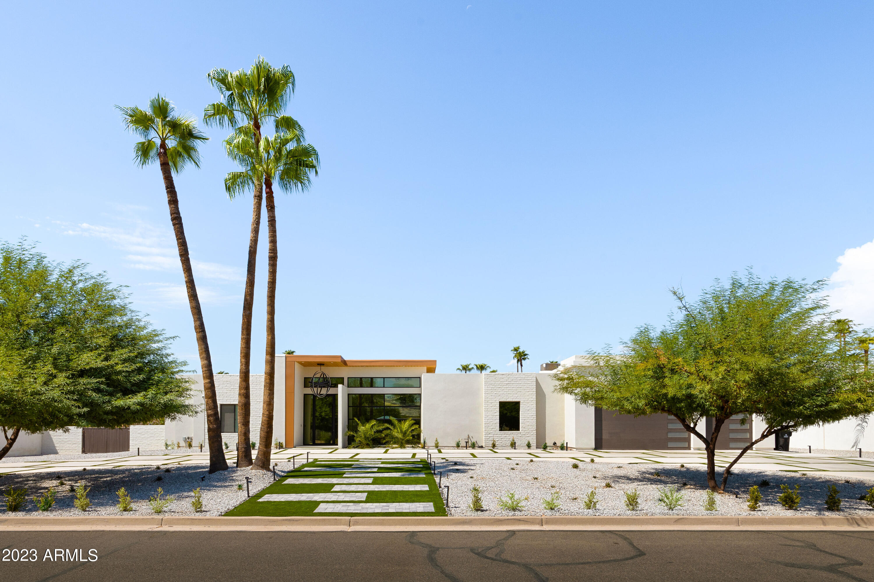 Contemporary Paradise Valley Oasis

Nestled in the prestigious Paradise Valley of Arizona, this fully remodeled contemporary masterpiece (completed in 2021) stands as a testament to modern luxury. Painstakingly reconstructed from the ground up, this home boasts 5 en suite bedrooms, including a convenient attached mother-in-law suite complete with a full kitchenette. A versatile 6th room, currently utilized as a gym, adds further flexibility to the space.

The primary suite is a haven of indulgence, showcasing a spacious walk-in shower and two walk-in closets, one of which soars to an impressive 12 feet in height. The main living area is a seamless blend of elegance and functionality, featuring white oak hardwood floors, open-concept design, and soaring 12-foot ceilings. High-end finishes abound, including a double island and a discreet hidden walk-in pantry in the gourmet kitchen.

Expansive sliding doors beckon you to the backyard, where an oasis unfolds on the sprawling lot. A long lap pool and inviting hot tub provide the perfect setting for relaxation and entertainment, complemented by two generous turf areas for recreation. Cinematic experiences await in the soundproofed theater room, complete with state-of-the-art surround sound.

Car enthusiasts will revel in the 3-car tandem garage, offering space for up to 6 vehicles and boasting extra high ceilings, providing room for lifts should the owner desire. This home is a symphony of style, sophistication, and comfort, where every detail has been carefully considered to create a living experience that is truly extraordinary.