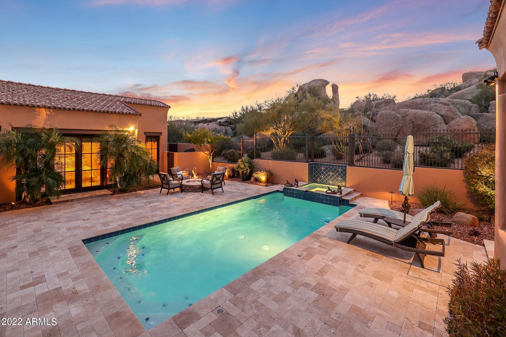 Stunning European inspired estate features 5,539 square feet of pristine and feature rich living. Located on the 14th hole of Troon North's Monument course, this unique setting has golf course views as well as local boulder formations and mountain peaks for ultimate privacy. Being sold completely furnished, this home is move-in ready!  The elevated lot has a courtyard entry and a four car garage (one bay is tandem). The interior is timeless and centered around the courtyard style pool setting allowing for multiple French doors to access the backyard from different rooms. The pool area is overlooked by unique boulder formations and features a sparkling pool with water feature, elevated spa, fire pit, tumbled travertine hardscape and covered & uncovered patio spaces for dining & loungi Vaulted beamed ceilings and clerestory windows offer a spacious feel to the living room with a centerpiece fireplace. Off the living room is a side patio with a four hole artificial turf putting green and a relaxing water feature. The kitchen is tucked away for privacy but easily access the living and dining spaces for entertaining. Kitchen features include stainless steel appliances, center island, gas cooktop, arched ceiling, charming custom details with a large walk-in pantry and an eat-in breakfast nook with exterior access. 

The master bedroom is accessed through a grand hallway with wall sconces, arched doorways and mosaic tile wall surround all in on it's own wing of the home. With views of the pool and boulders the setting is private and has a large bathroom with dual walk-in closets (one with a washer/dryer hook-up) and a spa-like setting. Above the master is an additional bedroom which could easily be a bonus/flex space perfect to fit any Buyer's need which also features wonderful views. (

Two additional guest rooms are also ensuite and equally opulent with hallway access to both the front courtyard and the pool area. A separate entrance guest casita finishes off the beautiful living spaces and includes a full bathroom, corner fireplace and a kitchenette, perfect for visitors.