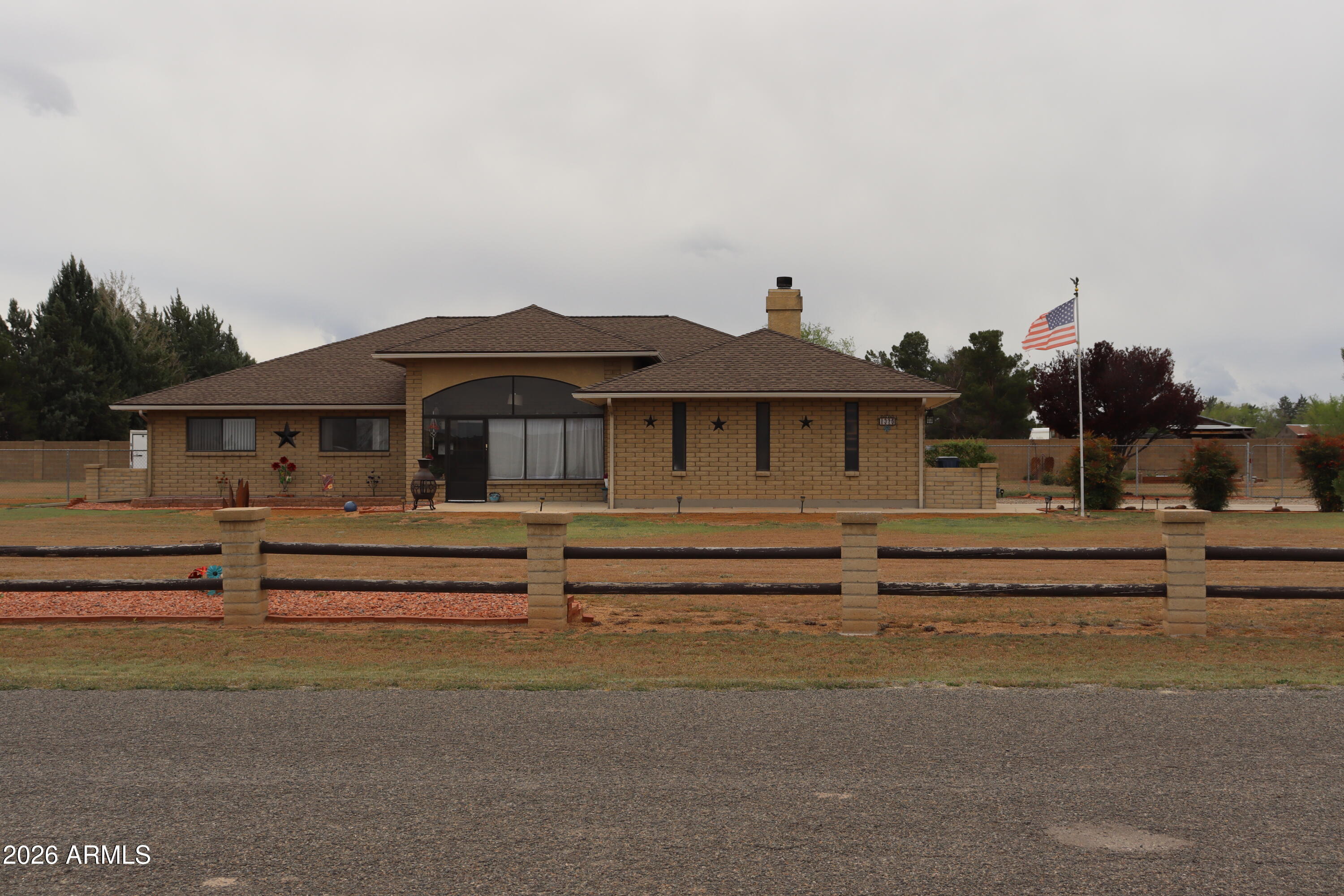 Welcome to your peaceful high-desert retreat at 1375 E New York Place, a charming single-level country home nestled on a spacious, fully fenced 1.16-acre lot with panoramic views of the valley and the stunning San Francisco Peaks. This inviting 3-bedroom, 2-bathroom, 2,153-square-foot home features an open-concept floor plan and a grand brick fireplace serving as the heart of the home. The massive chef-ready kitchen boasts abundant Corian counter space, endless cabinet storage, and stainless steel appliances, while the oversized master suite offers a large walk-in closet and a spacious bathroom with Two showers. Flexible bonus spaces are perfect for a game room, craft room, or office, supplemented by a dedicated laundry room with a utility sink. Outside, the horse-friendly property offers