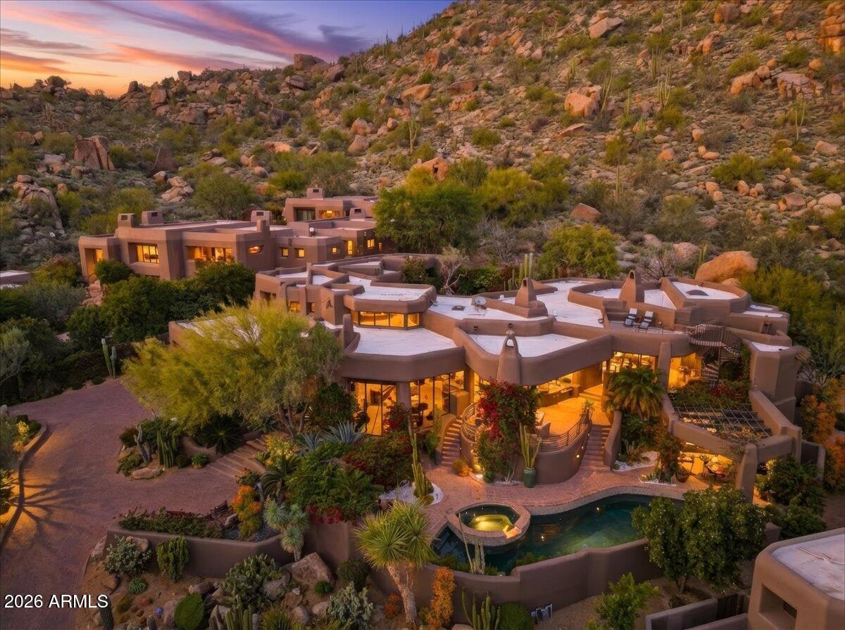 Views galore! (Seller will pay the $205,000 Membership with an appropriate offer.)This Lash McDaniel masterpiece is nestled into the base of Pinnacle Peak, drinking in vistas that words do not do justice. With your choice of entertaining and conversation courtyards, all with unique vantage points, 360 degrees of scenery from the rooftop deck, spectacular! Check out the Sunset & the City lights! Wow. Primary has his n hers closets, + owner office/sitting room. Kitchen is the nerve center of this expansive home, Furnishings convey. DH features a Nicklaus 18 hole course, clubhouse that is the hub of the community + a fitness center.  Live a resort like lifestyle, yet in 5-10 minutes you have a dozen restaurants, specialty shops, pharmacies, Starbuck's, and AJ's market. Quiet yet close!