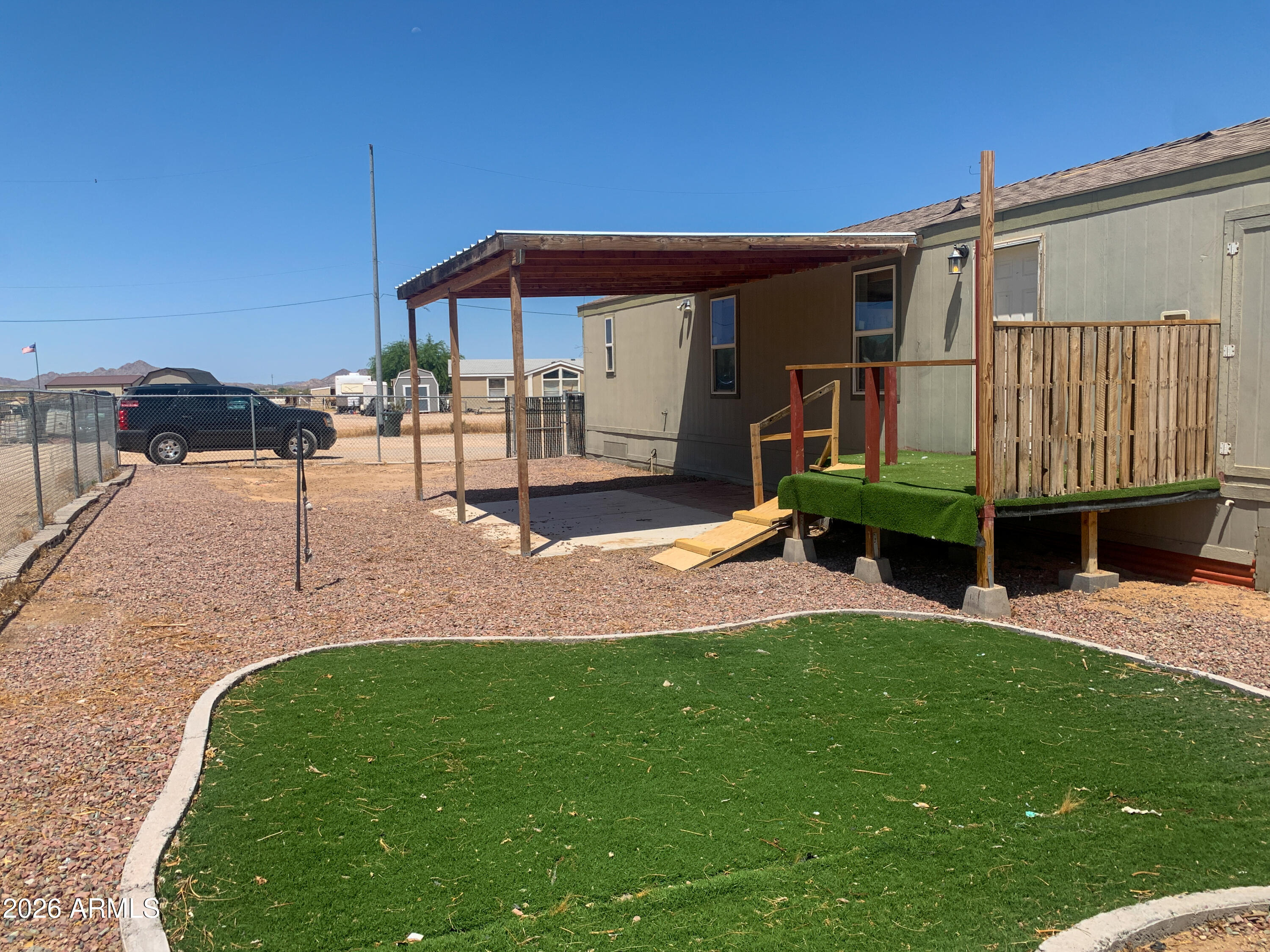 Built in 2017, this mobile/manufactured home offers 961 square feet of living space with 3 bedrooms and 2 bathrooms on a 60,835-square-foot lot. The interior features an open living area and ceiling fans throughout. The kitchen includes a breakfast bar, backsplash, stainless steel refrigerator, and stainless steel dishwasher. Exterior features include a covered patio and a fenced front yard area with turf.