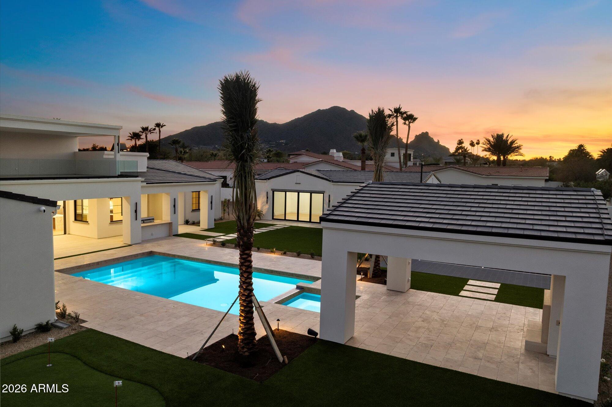New Gated Custom Estate Home in Paradise Valley by Award-winning Builder, Gray Properties,Inc. This finely crafted 7,340 SQFT livable home on an Acre Plus lot is walking distance to fine dining, upscale shopping, resorts, spas & golf courses. Nestled between Mummy & Camelback Mountains providing great Mountain Views!  The Main home boasts 5 Bedrooms/Office, 6 Bathrooms, a Game Room with wet Bar w/translucent Brazilian Cristallo Quarzite, View Deck with dramatic mountain and city light views, and extended length and height 5 Car Garage. The Guest House features 1 Bedroom, 1 Bathroom, Kitchen, Great Room & Laundry.  The Main Kitchen features double waterfall Statuariettio Italian marble islands & wolf subzero appliances. Estate includes Ramada, sport court, pool, spa, BBQ & putting green. Solid Rough Sawn Cedar wood beams in Living Room, Dining Room, Primary Bedroom, Office, Kitchen and Family Room. The Primary Suite also boasts custom built-ins, sitting area, dual: walk-in closets, beverage bar, dual vanities with Calacatta Umber Italian marble, & bidet water closets.  The office has floor to ceiling glass and views of Camelback Mtn.  The game room includes views of Mummy Mtn. and the estate also features a lit sports/pickleball court, ramada, BBQ w/sink & bar, pool & spa with deck jets and geyser, and 4 hole putting green.