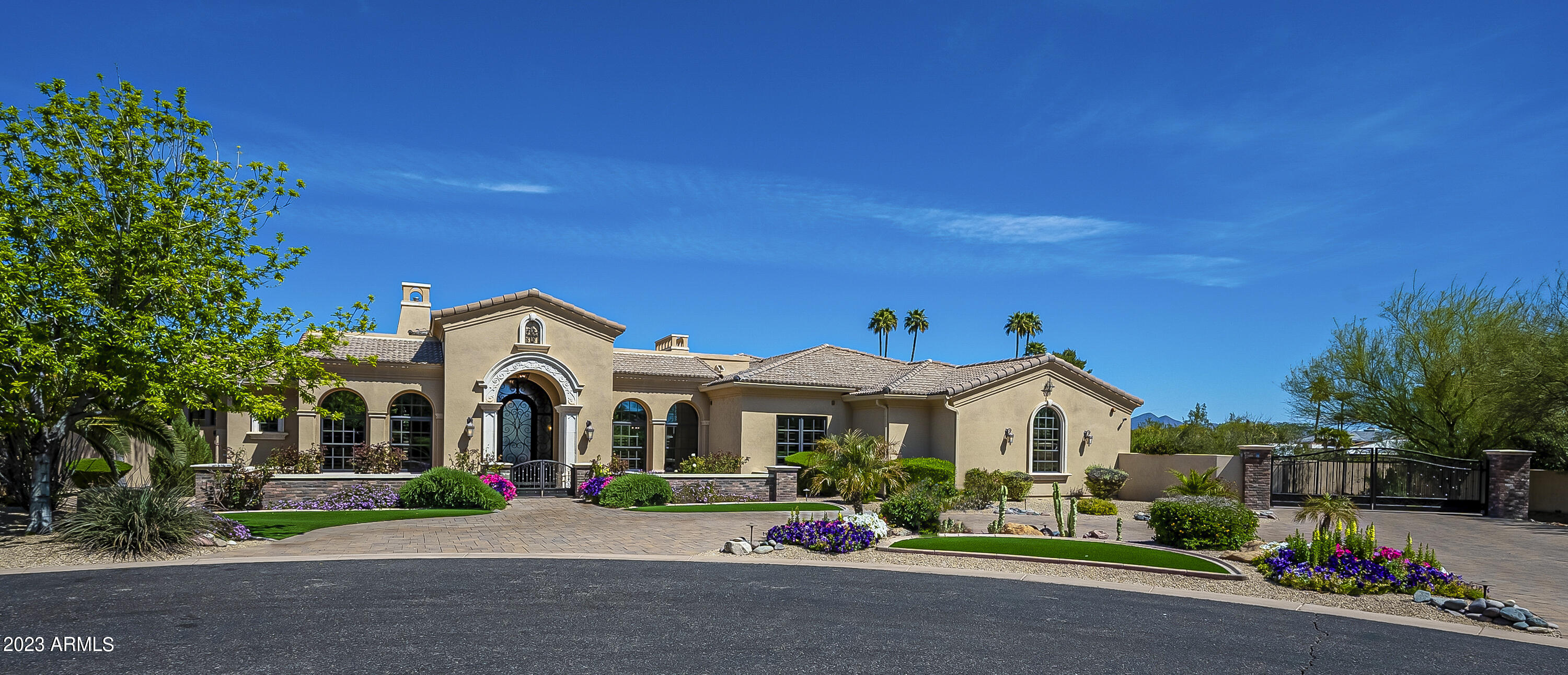This unique home invites you to experience the indoor/outdoor lifestyle of Paradise Valley. The estate sits on a quiet cul de sac featuring 6 bedrooms, 6.75 bathrooms, grand study, formal living/dining rooms, chefs kitchen, Wolf appliances, ice machine, granite island, and butlers pantry. An indoor gym offers game play for basketball (3 regulation hoops), pickle ball, tennis wall, and your active family.  The basement is a private hideaway with kitchenette, bar, ice machine, gaming area, 170'' home theatre with luxury seating. An oversized 4 car garage is conveniently equipped with an EV charger plug. The outside oasis beckons you to an Olympic size pool, cascading edge hot tub, covered patio, Wolf grill, gas firepit, garden, and majestic sunsets. The master suite has his/her commodes, dual sinks, jetted tub, fire place, etched glass, brick and stone trim, and exit to backyard.  Main floor has 4 full baths, a ¾ bath strategically placed for easy pool/gym access, and a powder room. Three main floor secondary bedrooms are ensuite for added privacy. The basement has 2 bedrooms (optional workout room), a full bath and powder room. The home boasts extensive architectural features with generous use of brick and natural stones.  This gem is ideally located within minutes to new Cholla Trailhead, Fashion Square, Ritz, Caesars Republic, and upscale restaurants with easy access to AZ 101.  Conveniently equipped with Home Automation. The home is move-in ready.