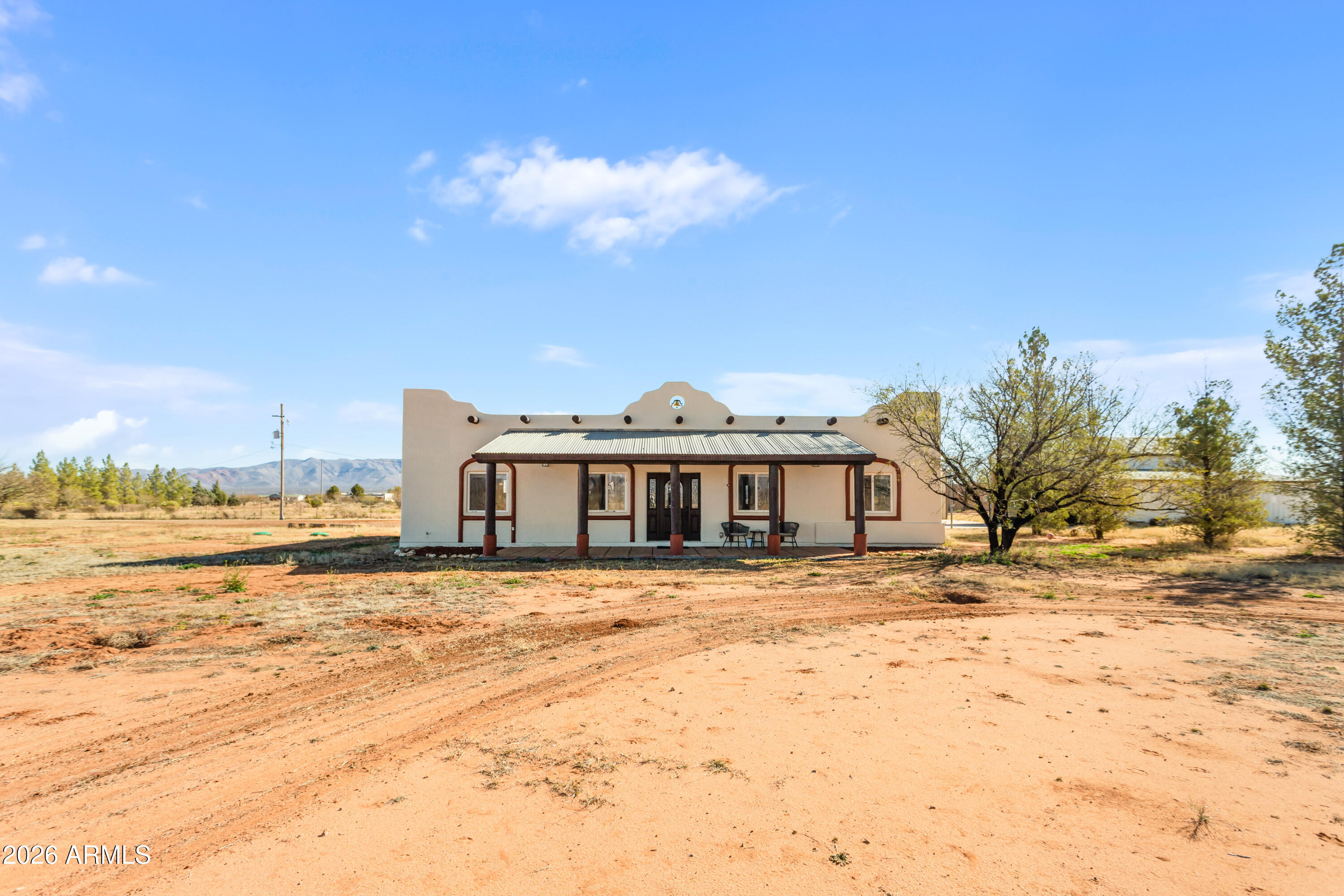 Incredible property set on a fully fenced, leveled, and cleared 4-acre parcel, this beautifully updated Santa Fe-style home offers sweeping wraparound mountain views and exceptional privacy. The exterior has been freshly painted and features brand-new flooring and cabinetry, along with newer appliances (within the last two years). The roof was replaced approximately two years ago, and a brand-new hot water heater adds peace of mind. Solar panels provide efficiency and long-term value. A 30' x 40' x 16' steel building includes 110/220 electric, RV hookup, lighting, cooling, and an extended concrete slab. An additional dual-height barn offers flexible space for vehicles, equipment, or RV storage--delivering a rare blend of elegance, functionality, and wide-open Southern Arizona living.