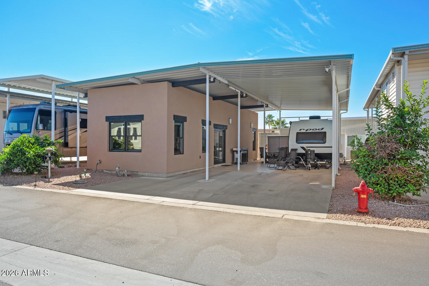 MOVE IN READY! This is a spacious RV lot with a 3-year-new stick built AZ home. This home has a plethora of upgrades to include Anderson mirrored-tinted windows, R19 walls, R38 ceilings, 9' ceilings, granite counter tops, mini-split HVAC,  ''Zip'' sheathing system, & a fresh air exchanger. Kitchen includes Frigidaire appliances. The covered RV port is 12 feet in height with plenty of room for an outdoor patio. GOLF CART (with 1 yo lithium batteries) & OUTDOOR BBQ ARE INCLUDED! Happy Trails RV Resort is a 55+ active adult, guarded community featuring an on-site restaurant, post office, low HOA dues, & NO LAND LEASE! Experience AZ living and a vibrant social scene. This is more than a home - it's a lifestyle! Conveniently located in Surprise, AZ near shopping, medical, golf, sports, & more.
