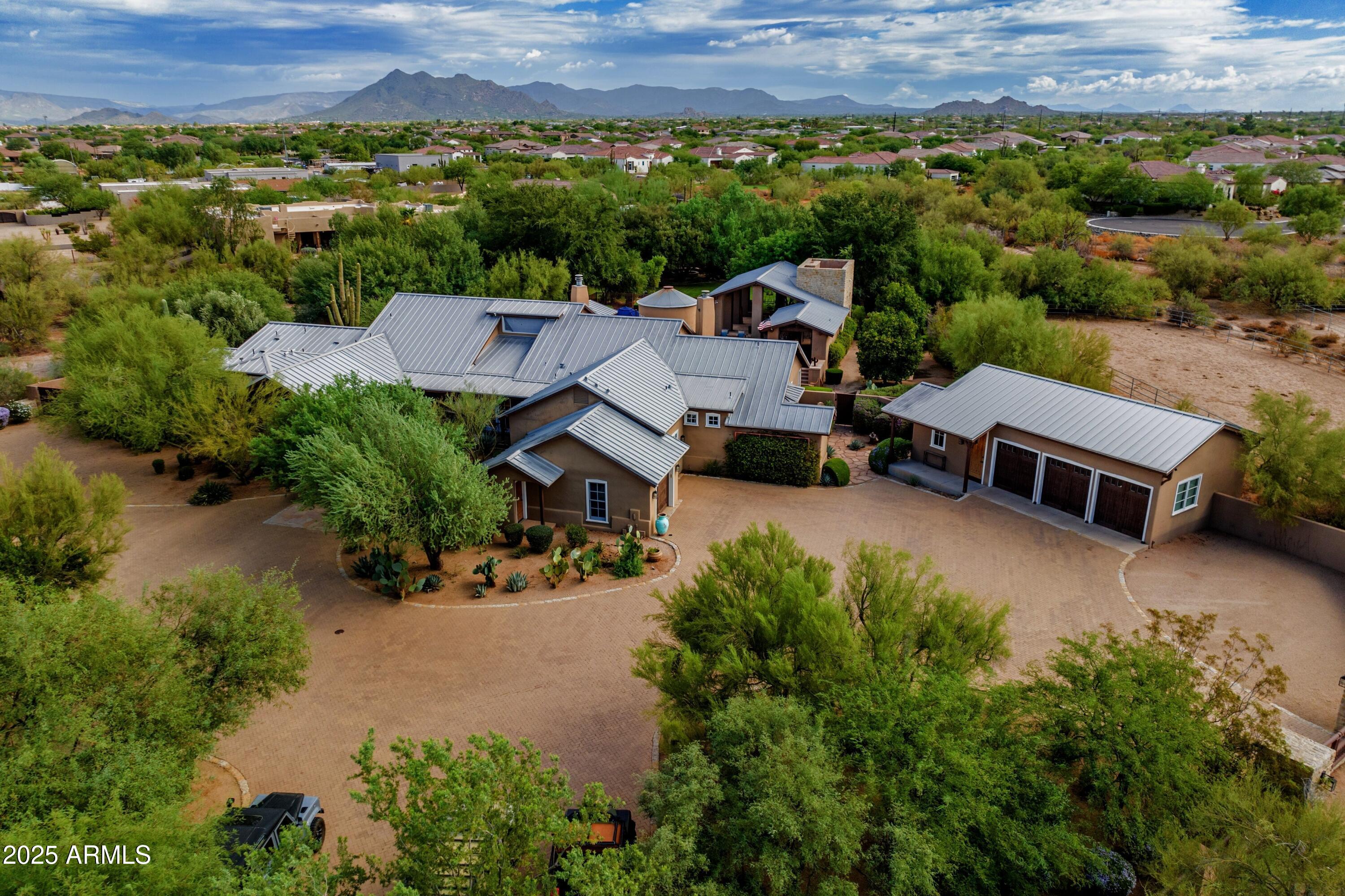 Exceptional Desert Star-built equestrian estate, located adjacent to the renowned Bellissima Equestrian Facility. Designed by the Dorrance family, spans over 5 acres with 7 bedrooms and 8.5 baths, with a main home over 5,700sf coupled with a 2,700+sf guest home, totaling to 8,500sf of refined living space. Constructed with the highest quality materials and well-appointed finishes. Authentic and charming property offers luxurious outdoor amenities including an outdoor kitchen, wet bar, an expansive Texas Limestone covered entertainment patio, multiple fireplaces, an enormous grass backyard, citrus grove, and a stunning heated pool and spa. Car enthusiasts will delight in the 7-car garage, all within a gated compound on paved roads. An opportunity like this is rarely available at at this per sqft offering price... a perfect multi-generational estate where privacy matters most. This 5 acres has been split and recorded and is separate from the equestrian facility. The lot split includes 2 covered turnouts on the SE side of the parcel previously part of the equestrian facility.