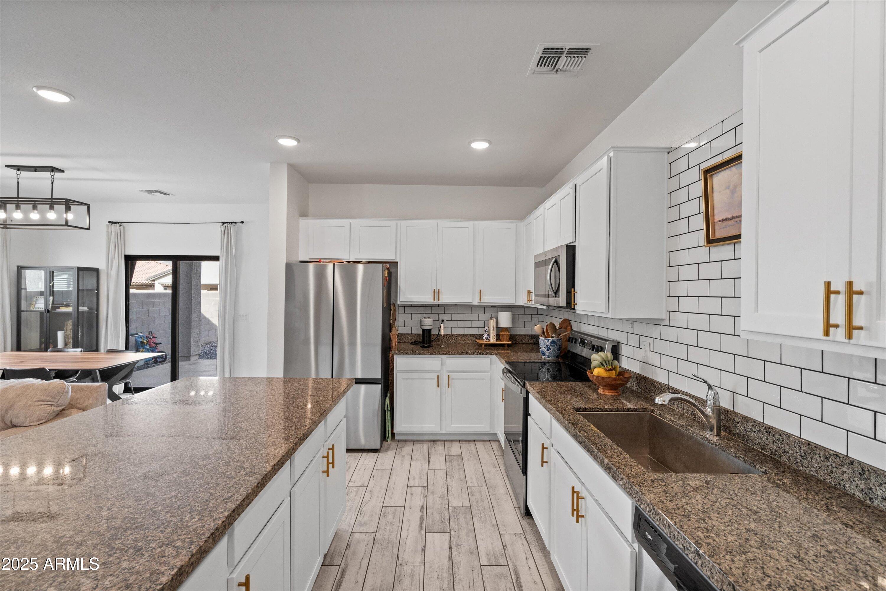 Welcome to this stunning 3-bedroom, 2-bath home built in 2022, offering the perfect mix of comfort and modern style. Step inside to a bright and open floor plan that's ideal for entertaining, featuring a beautiful kitchen with white cabinetry, granite countertops, and a designer backsplash. The flexible den is perfect for a home office or can easily be converted into a fourth bedroom. Tile flooring flows throughout the main living areas, while the bedrooms feature durable vinyl flooring installed in 2023 for a seamless, carpet-free look. The backyard offers low-maintenance gravel landscaping with paver accents, ready for your personal touch. Located in a fast-growing, family-friendly community close to schools, parks, and shopping!