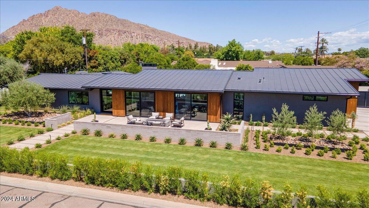 Unlike anything else on the market. This Visually stimulating and functional home is sure to please.  Floor to ceiling sliders, glass pivot door and store front glass windows throughout allowing an abundance of natural light to enter. Enjoy 10 and11' vaults throughout for interesting roof lines. Rift oak and book matched walnut custom cabinetry help to warm  the space and adds to a super cool vibe.  Subzero commercial fridge, concrete look counter tops, Brizo and California faucets reminiscent of very clean  mid century modern home. Designed to cater to a busy family with office, flex space, 2 master bedrooms, laundry room with double stack washer/dryers, fridge, custom rift oak / steel bar with beverage/wine fridges and plenty of storage...Pre cast concrete fire pit, burnished block, exposed aggregate decking and killer landscape package add to that modern desert oasis.  Custom Kebony cladding, terrazzo tile and 3 car garage with epoxy coated floors are just a few welcoming touches. All while being within a mile of some of the best restaurants, shopping and schools that the Valley of the sun has to offer.