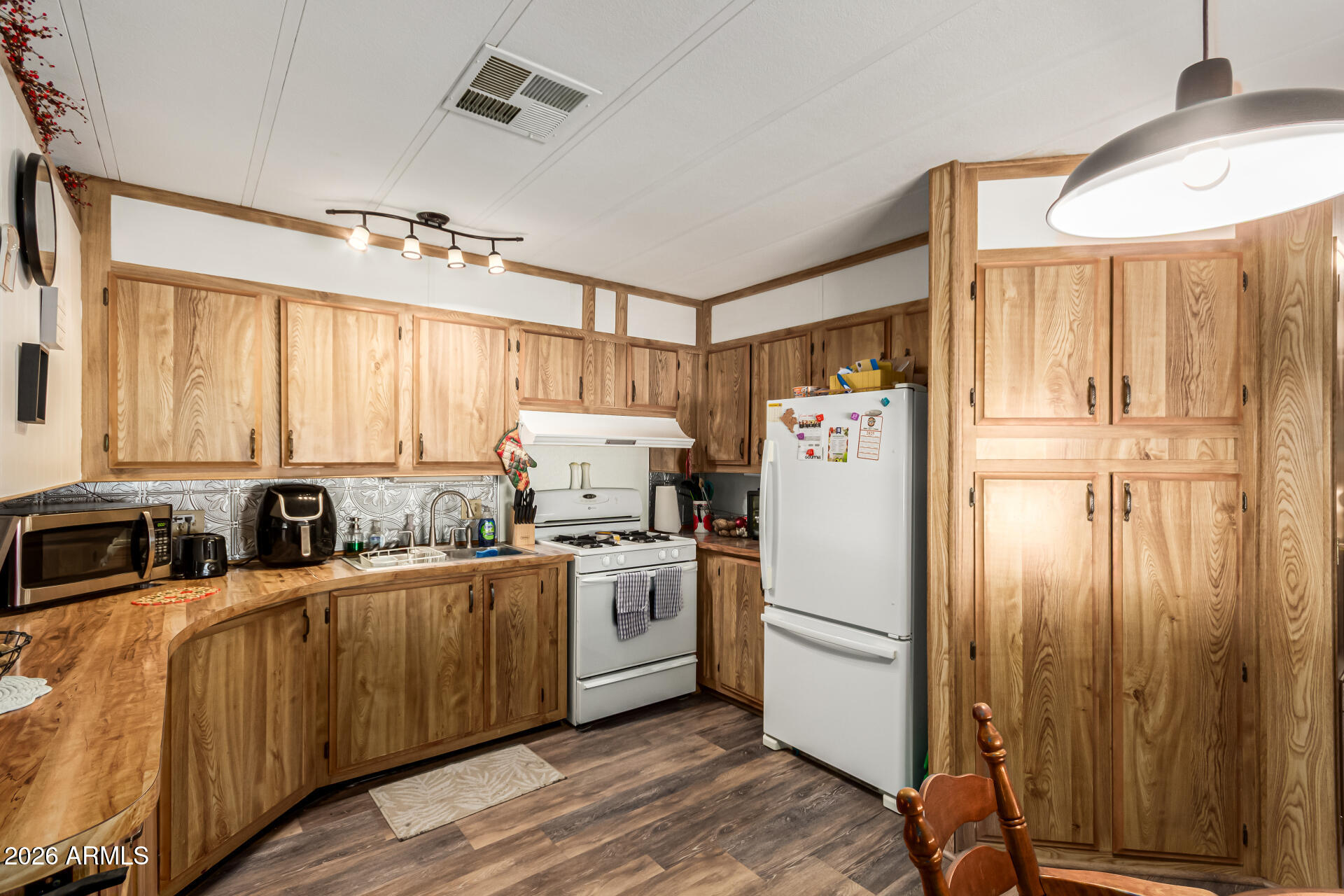 Seize the chance to own this 2BD/2BA mobile home in Rosehaven Estates! You'll be greeted by a front porch, perfect for enjoying a cup of morning coffee and a 1.5 car/golf cart covered carport. Inside, you'll find an open layout with a soothing palette, wood paneling, ceiling fans and wood vinyl plank flooring for a timeless appeal. The kitchen comes with wood shaker cabinetry, built-in appliances including a gas stove, and an island with a breakfast bar for quick meals. The AC is 3 years old, the roof shingles are 3 years old, hot water heater is 2 months old and all furniture conveys. This home also includes a storage shed and a workshop. Active  Community includes two sparkling pools, a pickleball court, a dog park, a library, a gym, and more