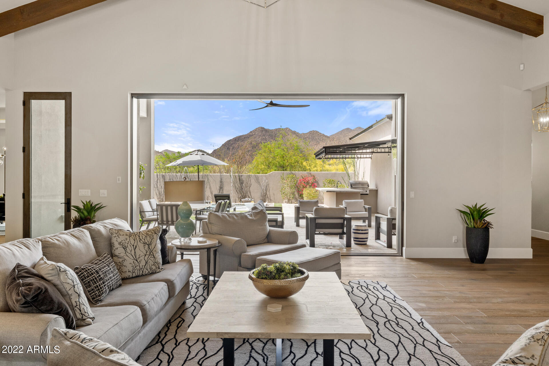 This nearly-new soft contemporary home has breathtaking mountain views from every room! 10' tall automated wall of glass from the great room leading to the large covered patio perfectly frames the beautiful mountain view and brings the outdoors in for seamless indoor/outdoor living! Wide open floor plan.  Stunning chef's kitchen  with 2 islands, leather granite and Quartz countertops. 60''Wolff range, full size Sub Zero refrigerator and freezer, Meile coffee system and 2 full size wine closets with glass fronts. Wide plank wood floors, exposed stained wood beams on the ceiling. Large 2 room attached casita with separate entrance, includes family room with kitchenette, bedroom and walk-in closet, bathroom and full size washer/dryer. Highest quality finishes include LED accent lighting, contemporary designer light fixtures and fans through out, 10' solid wood doors, 3 linear fireplaces. Master retreat with electric blinds enables you to wake up to the spectacular views! Fireplace and sitting area, beverage bar, his and hers closets with a full size washer dryer. Stunning master bath with floating vanities, free standing tub with metallic wall feature  The backyard oasis includes a  covered BBQ and cook area including sink, refrigerator. Heated pool with beach entry and built in chaises, water and fire features, heated spa and putting green.