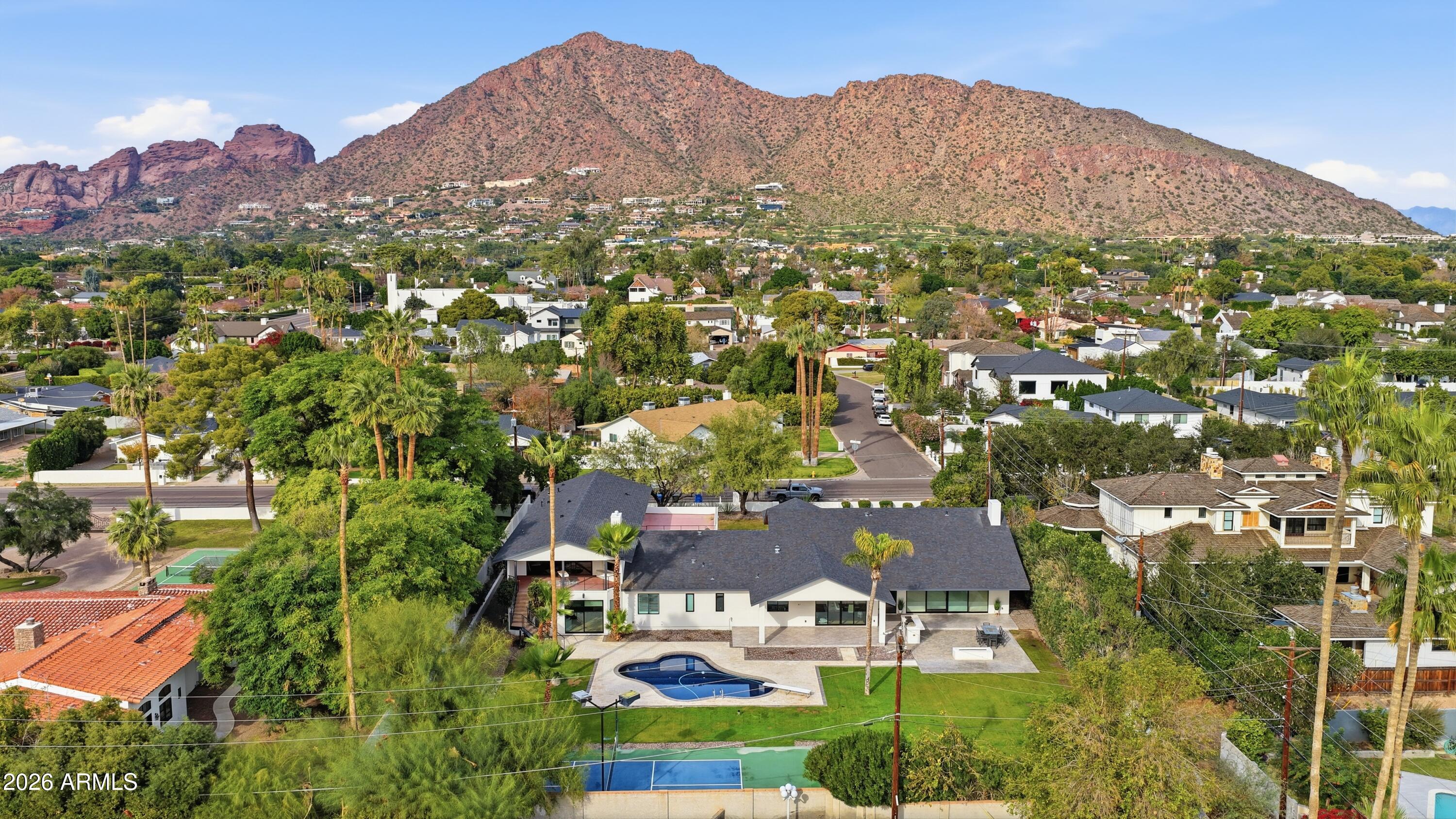 NOW THE BEST PRICED ESTATE IN ARCADIA under $5M -7,418 sqft on ~0.7 acre lot with unobstructed Camelback Mountain Views, Guest Wing, and Private Pickleball Court. Set on an expansive Arcadia lot, this contemporary estate delivers exceptional scale, privacy, and true separation.  Open, light-filled living spaces center around a chef's kitchen with Wolf and Sub-Zero appliances, dual dishwashers, and an oversized marble island built for entertaining. Seamless indoor-outdoor flow connects the home to resort-style grounds featuring a full pickleball court, expansive pool, and natural grass lawn.  A fully independent guest residence complete with its own kitchen, living, and dining areas offers rare flexibility for multigenerational living, extended stays, executive workspace, or live-in support Recently refreshed and pre-inspected, including new AC systems, full interior repaint, refinished hardwood floors, new shutters, epoxy garage floor, and inspection items addressed.  This home was voted "BEST HOME ON TOUR" and you will see why when you come to visit!  Homes with this combination of size, land, and amenities are rare at this level.  

Seller plans to review offers on Monday April 20 but reserves the right to accept a strong offer prior.