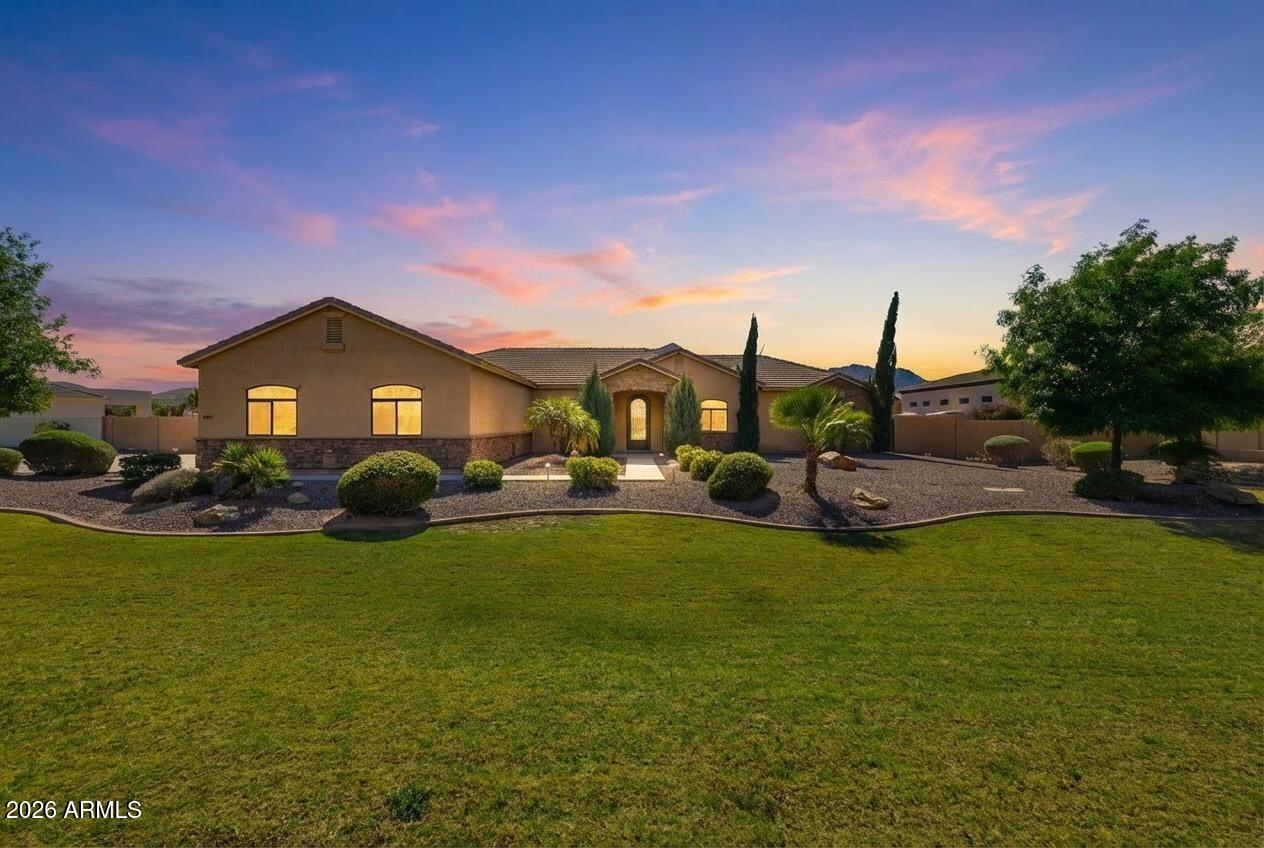 Custom built, recently renovated, and move-in ready, this is one of those rare homes that checks every box. Properties like this, with this much space, privacy, and flexibility, don't come along often. This is the kind of home you move to when you want space to breathe, room for everyone, and the feeling of having truly arrived. Located in the quiet community of Creekside Estates in San Tan Valley, this custom home sits on a full acre with beautiful views of the San Tan Mountains and a sense of privacy that's getting harder to find. Thoughtfully expanded in 2024 with a 1,200sqft addition, the home was reimagined to better fit modern living, including a stunning kitchen remodel, a dedicated dining space, and a second primary suite. The result is a layout that works beautifully for multigenerational living, long-term guests, or simply having your own private retreat. With six bedrooms and five full bathrooms, there is room for everyone to have their own space. The two primary suites are true sanctuaries, each with beautiful en-suite baths and custom walk-in closets. One of the primary suites includes a flexible bonus room that works perfectly as a private office, nursery, or quiet sitting room. Closets and storage are everywhere, and the large pantry makes everyday living easy and organized. The kitchen is both functional and beautiful, featuring an induction cooktop, double ovens, and thoughtful under-cabinet lighting that brings the space to life. Recent updates include 3 new AC systems (one for the addition in 2024 and two for the original home in 2025), two new water heaters, and a whole-home water filtration system, making this home truly turnkey. Outside is where this property really shines. The heated sport pool with a sun shelf creates the perfect space for entertaining, relaxing, or making memories with grandkids. The acre lot offers room to garden, gather, or simply enjoy the quiet, open setting. Fruit trees including lemon, Mexican lime, and orange add a personal touch, while the peaceful surroundings and mountain views remind you why people love this part of the Valley.