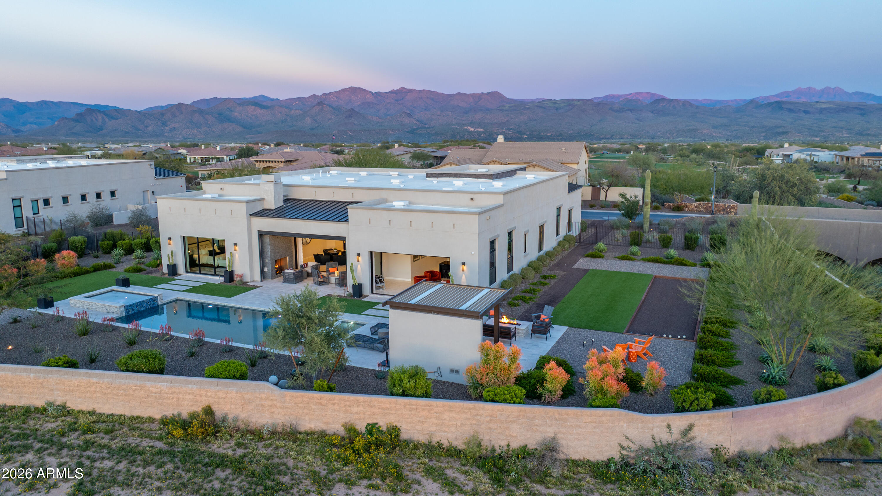 A Desert Modern Masterpiece awaits in the remarkable 24-hour guard-gated community of Trilogy at Verde River. This Toll Brothers home was designed as both a retreat and a statement, offering over $900,000 in curated upgrades and intentional design. A striking entry welcomes you into a soaring foyer crowned by a 14-foot ceiling. Every finish has been intentionally crafted to create an atmosphere of calm sophistication. The great room serves as the heart of the home, framed by 14-foot ceilings and expansive sliding glass doors that seamlessly connect indoor living to the serene desert backdrop. The open-concept design flows into a chef's kitchen anchored by a dramatic granite waterfall island. A professional-grade appliance suite from Sub-Zero and Wolf includes dual dishwashers, while a built-in coffee bar, wine refrigeration, and a butler's pantry elevate both everyday living and large-scale gatherings. For more intimate settings, a dedicated bonus room with a built-in bar offers the perfect atmosphere for evening cocktails and conversation. 

The primary suite is a private sanctuary featuring dual illuminated vanities, a freestanding soaking tub, and a glass-enclosed shower. The custom walk-in closet provides exceptional organization. The home offers two generously appointed guest bedroom suites that provide comfort and versatility, complemented by a separate executive home office with glass French doors offering both privacy and natural light. Guests enjoy their own refined retreat in the attached casita, which offers a private exterior entrance from the courtyard for comfort and discretion. Throughout the home, you will find electronic silhouette shades by Hunter Douglas and designer lighting. 

Positioned on a 24,500-square-foot homesite, the backyard is a $550,000+ resort-caliber landscape designed by Creative Environments. This outdoor oasis features a heated saltwater pool and spa, a bocce ball court, and a covered patio anchored by a statement fireplace and Havana electric shades. A fully equipped outdoor kitchen with a professional grill and smoker invites effortless al fresco dining. As the sun sets, the horizon softens to hues reminiscent of chilled rosé, with blush tones stretching across the desert sky. From the epoxy-finished three-car garage with a Tesla EV charger to advanced water filtration systems, every element of this residence reflects a seamless union of luxury, innovation, and intentional living.

Life at Trilogy at Verde River is anything but ordinary. Challenge yourself on the Tom Lehman 18-hole golf course, the dedicated pickleball and tennis courts, or the professional bocce ball courts before relaxing in the resort-style pools and hot tub. Power up at the Afterburn Fitness Center or get creative in Helen's Demonstration Kitchen and the Art Loft. While your pups roam the 7.5-acre dog park, you can savor everything from casual bites at Eddy's Diner to sophisticated flavors at Needle Rock Kitchen & Tap. With Alvea Spa on-site and the majestic Tonto National Forest trails just beyond your doorstep, every day is a perfect blend of adventure and indulgence.
