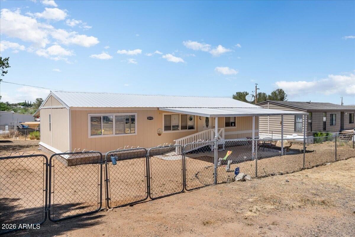 Here is the definition of AFFORDABLE HOUSING & it is a 1987 Double Wide on .16 Acres with a 1 Car Carport & it has a durable white STEEL ROOF. Home features 1248 Sq Ft, 3Bedrooms, 2Bathrooms, Open/Split Floor Plan, GREAT ROOM Concept, Vaulted Ceilings, Ceiling Fans, Luxury Vinyl Wood Plank & New Carpet in Bedrooms, New 2 tone Interior Paint, & Horizontal Blinds. Kitchen has Oak Cabinetry, attractive Laminate Countertops, Electric Range, Stainless Steel Fridge, Built-In Pantry, & RO Filter.  Master is Spacious with New Carpet, Full Tub/Shower with Tiled Surround, Tile Floor, Single Sink, & Walk-In Closet. Guest Bath has Tub/Shower with Tile Surround, Bedroom #2 has Walk-In Closet, & 3rd Bedroom is being used as Den. Additional Features include Laundry Room w/Washer & Dryer Conveying, ... Fenced Perimeter, Dog Run, New Exterior Paint, Stem Wall Foundation, 8'x10' Storage shed on slab, Covered Front Patio w/Handicap Ramp, Covered Back Patio, & the 42" Visio Television conveys.