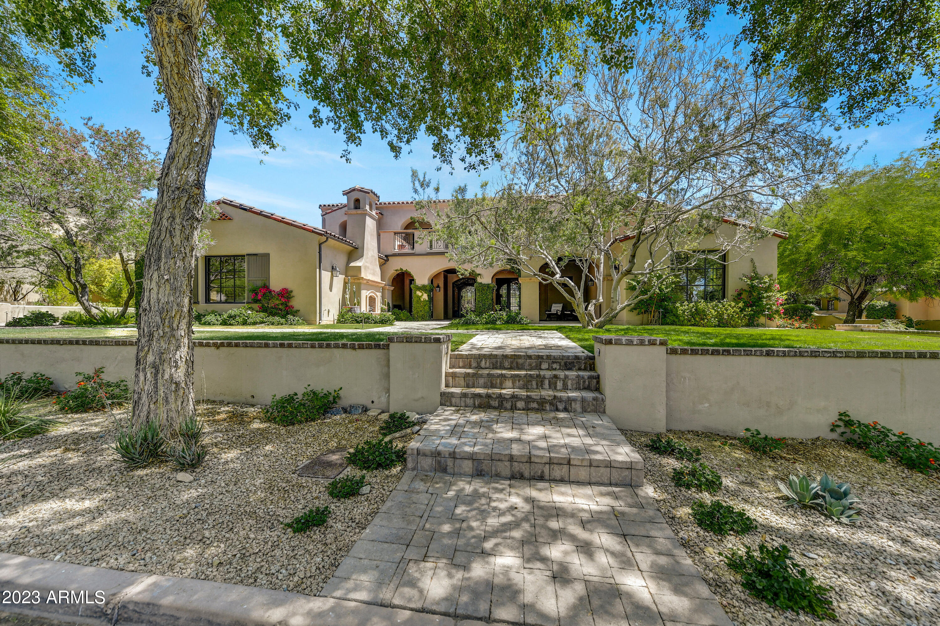 As you approach this astounding estate that boasts five en-suite bedrooms, you will be charmed by the character and inviting courtyard; enjoy one of the many cozy fireplaces overlooking the tree-lined street and common area and park. Entering through this custom wrought iron door, you are welcomed by sheer timeless beauty. Electronically controlled large pocket doors that open the entrance of the home all the way to the patio and pool area for free flowing entertainment. The gorgeous primary suite with individual custom closets and a spa bathroom. Two water closets and a large walk-in shower, and a separate office separated by custom glass doors are on the main level, with three additional spacious en-suite bedrooms upstairs. The fifth en-suite bedroom is a casita situated in the front. Your gourmet kitchen will be a delight to entertain, including wolf appliances, climate controlled wine fridge, four-draw dishwashers, a built-in sub-zero fridge and freezer built-in coffee station, a huge kitchen island, a large food pantry and a sunken bar with additional wine fridges and ice makers and pocket windows to enjoy from inside and out. A very spacious living room with another one of the many Cantera stone fireplaces sets the mood to relax and enjoy the views of the stunning pool and cabana-covered spa. Upstairs Bar Entertainment area with access to back patio overlooking the mountains includes Coffee Station for morning sunrises and additional Wine and Beverage Storage Unit for use with the front patio overlooking the park for evening sunsets. Additional Upstairs TV Bar area with Wine and Drinks Storage Unit to support the large TV with surround sound and card table for entertaining or family fun night. Control4 home automation, sound and security system including multiple sound areas including high definition sound system for the entire backyard with isolated sound areas for the BBQ, Pool, Patio and upstairs deck over looking the mountains.  This allows the home to have a full sound throughout the home and yard for entertainment or to isolate to a specific area for more intimate listening. Large 3-car garage with epoxy floors and plenty of storage.  Garage is large enough to house even the largest SUVs