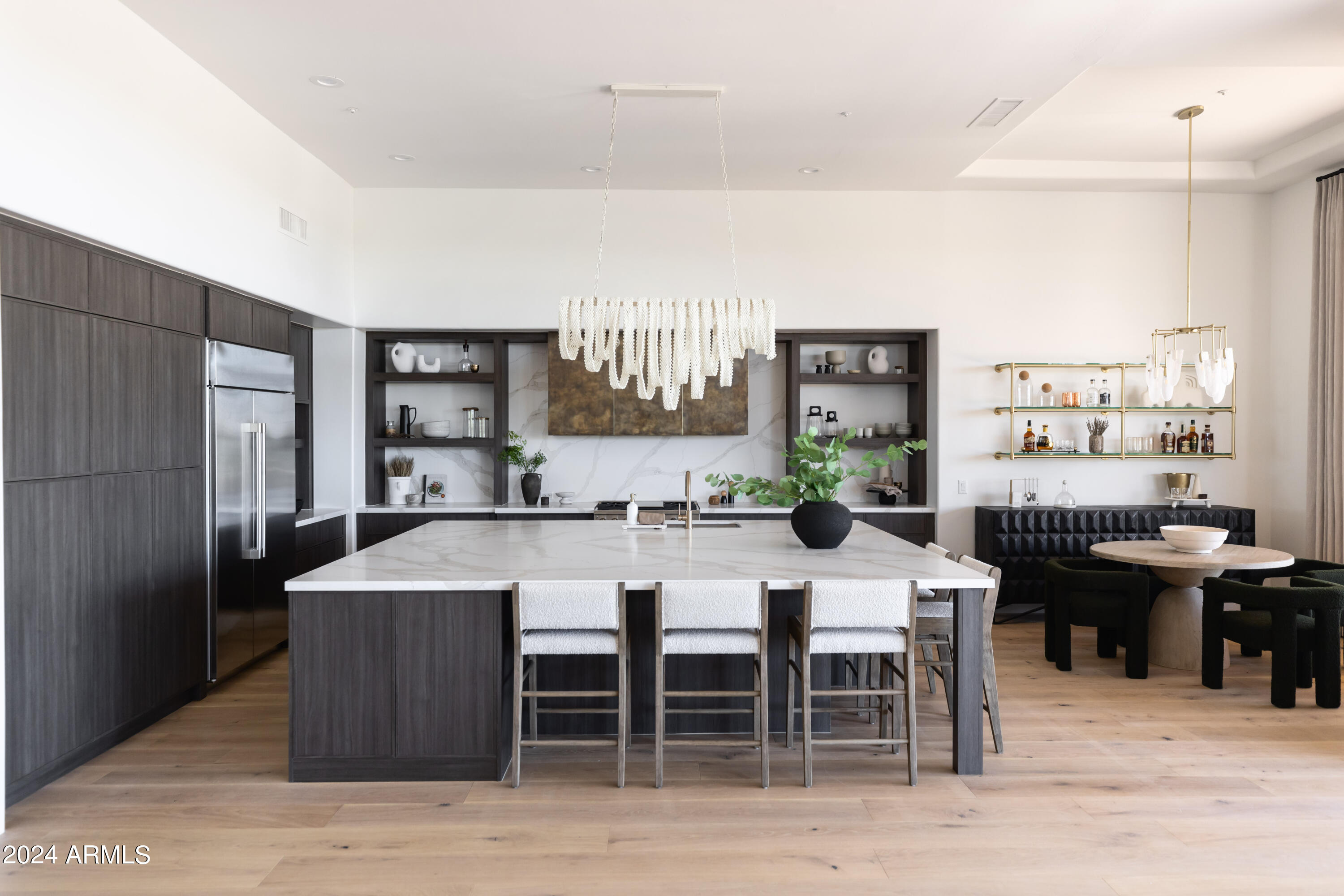This exquisite residence, a custom-built modern southwest home, has undergone a stunning transformation by Phoenix's top Interior Design Firm, Living with Lolo. With most of the living space on the first floor, including owner's suite, two additional bedrooms with en suites, an office, and full powder bath, upstairs you'll find the perfect space for a guest casita and/or game room.

The spacious and open floor plan seamlessly blends contemporary design with the charm of the Southwest. The heart of this home is its chef-inspired kitchen, boasting custom cabinetry, sleek quartz countertops, and high-end appliances. Whether you're preparing a gourmet meal or simply enjoying your morning coffee, the kitchen offers beautiful views that extend into the expansive great room. Beyond lies a panorama of natural beauty, with vistas of Troon North's Pinnacle golf course, Pinnacle Peak, and breathtaking sunset views.(

The owner's luxury sanctuary includes a spa-like bathroom and a private outdoor sitting area, meticulously designed for comfort and indulgence.

The two additional bedrooms on the first floor each have their own private bathrooms and walk-in closets.

The upstairs guest space is accessible via an elegantly curved staircase and features a living space with wet bar, bedroom and full bath. The balcony offers stunning views of Pinnacle Peak, the golf course and city lights.

This home is an entertainer's dream, blending awe-inspiring views, exclusive privacy, and the prestige of residing on the Troon North Pinnacle Course. Discover a home that not only meets the highest standards of modern luxury but also captures the essence of Arizona's unique beauty. Welcome to an elevated lifestyle where every detail reflects the pinnacle of sophistication and refinement. Furniture and accessories also available.
