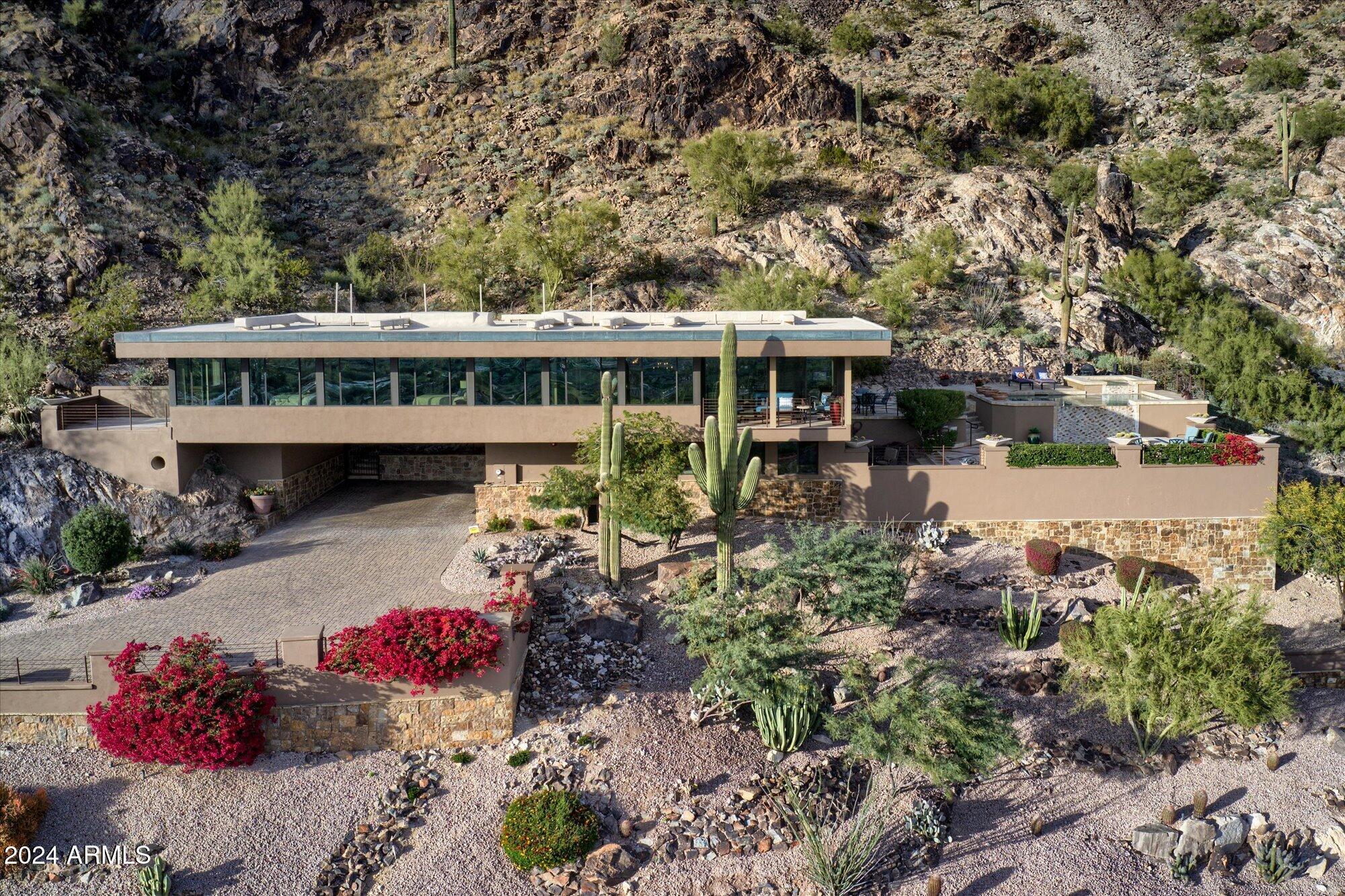 Discover unparalleled luxury in Paradise Valley with this stunning 3-bedroom, 3-bathroom home plus den, perched on one of the highest lots on Mummy Mountain. This exceptional property showcases exquisite wood flooring, beamed ceilings, alder doors, and stained trim, creating a warm and inviting ambiance.The open chef's kitchen is a masterpiece, featuring solid wood cabinetry, granite countertops, and premium Sub-Zero and Wolf appliances. Retreat to the elegant primary suite, complete with a private patio and a spa-inspired bathroom offering dual vanities, an open shower, a soaking tub, and a spacious walk-in closet. Step outside to your private desert oasis, boasting a negative-edge PebbleTec pool, elevated spa, and a linear fire pit—all framed by breathtaking, endless views.