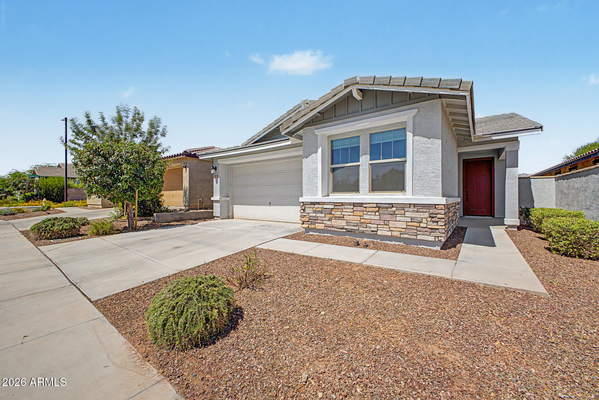 Charming 3-bedroom home in The Traditions at Verrado! Discover a stunning open floor plan accented by soft gray tones and wood-look tile flooring, creating a modern and inviting atmosphere. Expansive sliding doors seamlessly blend indoor and outdoor living, ideal for entertaining. The kitchen is equipped with white cabinetry, dark granite countertops, stainless steel appliances, and a generous island with breakfast bar. All bedrooms feature plush carpeting and abundant natural light. The primary suite has an ensuite with dual vanity, an oversized step-in shower, and a walk-in closet. The backyard is a blank canvas, ready for your personal touch. Perfectly situated across from Central Park, close to schools and the Verrado Golf Club, offering easy access to AZ-303 and I-10 freeways.