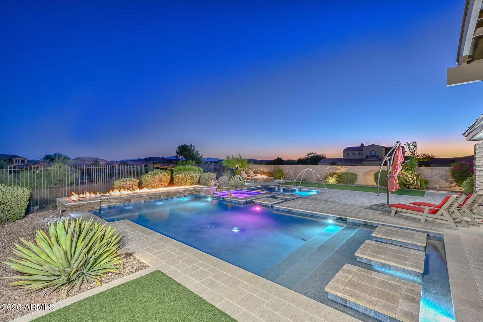 Located in the prestigious gated community of Blackstone Country Club, this exceptional custom estate offers panoramic golf course and mountain views along the 16th hole. Built in 2020, the 4,517 sq ft residence features 5 bedrooms, 4.5 baths, and sophisticated contemporary architecture designed for both luxury and everyday living. Expansive living spaces showcase soaring ceilings, large-format tile flooring, stone accents, and dramatic 90-degree multi-slide glass doors. The kitchen is a showpiece with dual islands, waterfall-edge quartz countertops, designer backsplash, and custom soft-close cabinetry. A private guest casita provides ideal accommodations for visitors. Resort-style outdoor living includes a heated pool, spa, Baja shelf, deck jets, fire features, BBQ, and gas fireplace! Energy-efficient features include a 65-panel owned solar system, pool heat pump, and Kinetico whole-house water system. Oversized 3-car garage with newly installed R-18 insulated garage doors. PVC irrigation lines added in 2026. Professionally designed backyard includes synthetic turf and multiple entertainment spaces. A/V equipment is being updated in Summer 2026. Situated on a premier golf course homesite within one of North Peoria's most sought-after private golf communities, offering luxury living, exceptional views, and outstanding indoor-outdoor entertaining.