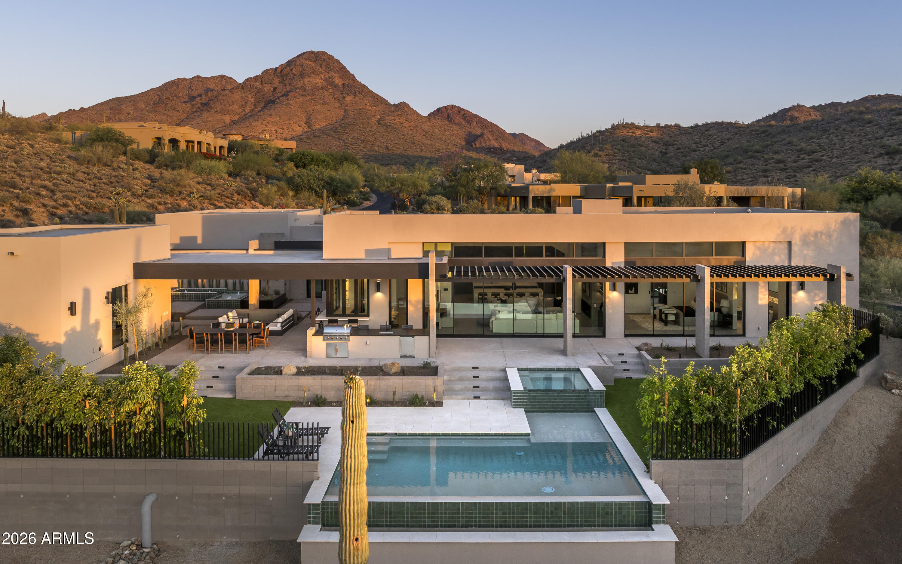 Located in the prestigious guard-gated community of Troon Village Country Club, this exceptional North Scottsdale estate offers nearly an acre (0.98 acres) of refined desert luxury in an A+ location. Designed and developed by Teran Developments and interior designer Joel Contreras, and built by Impact Build LLC, the property showcases impeccable craftsmanship and thoughtful design throughout.

The 4,500 sq ft main residence, paired with a 1,000 sq ft detached guest house, offers a total of 5,500 sq ft of livable space featuring 5 bedrooms and 5.5 bathrooms. The guest house includes a private living room, full kitchen, laundry, and its own garage--ideal for extended stays, multigenerational living, or visiting guests. Inside the main home, four en-suite bedrooms with walk-in closets provide comfort and privacy. A private office with built-in coffee bar, formal dining room, butler's kitchen, entertainment bar, and secondary living room create ideal spaces for both everyday living and entertaining. Dual laundry rooms--including a private primary suite laundry--add convenience, while custom water features enhance the home's tranquil ambiance. Step outside to a resort-style backyard complete with pool, spa, covered patio, and full pool bath. Car enthusiasts will appreciate the oversized 4-car garage configuration, including a 3-car main garage with lift options, a separate 1-car casita garage, and additional slab parking.