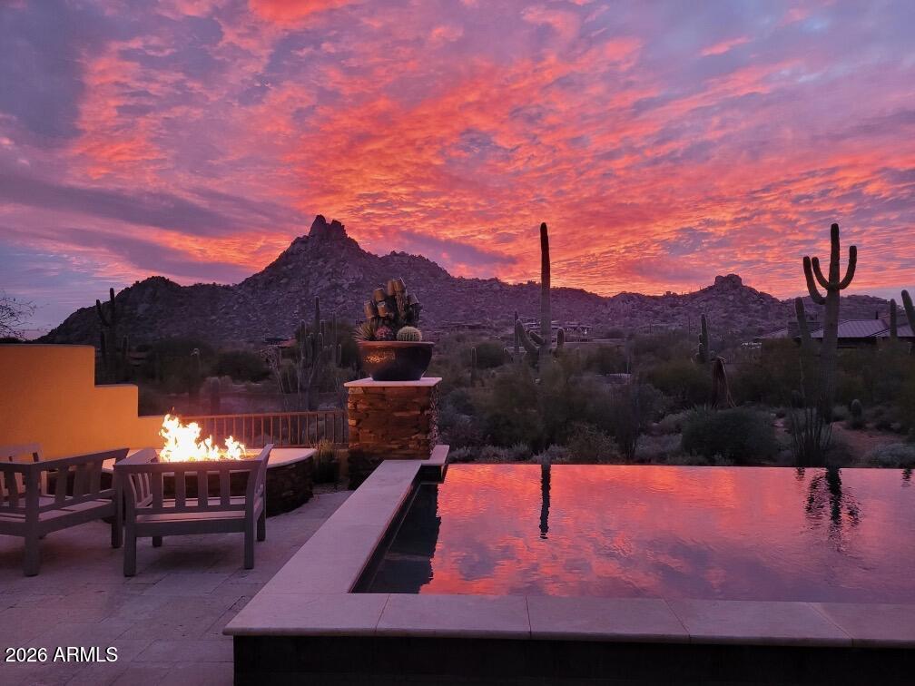 Nestled within the exclusive gated enclave of Privada at the Four Seasons Resort Scottsdale, this exceptional residence offers refined desert luxury and breathtaking views of Pinnacle Peak and the surrounding Sonoran landscape. Thoughtfully designed in the timeless Southwest style, the home features expansive open living spaces, wood-beam ceilings, and seamless indoor-outdoor living. The resort-style backyard is ideal for entertaining, complete with a pool, spa, outdoor fireplace, and built-in BBQ. A detached guest casita provides private accommodations for visitors or a home office. Enjoy world-class resort amenities, dining, spa services, and golf nearby in one of North Scottsdale's most coveted communities.