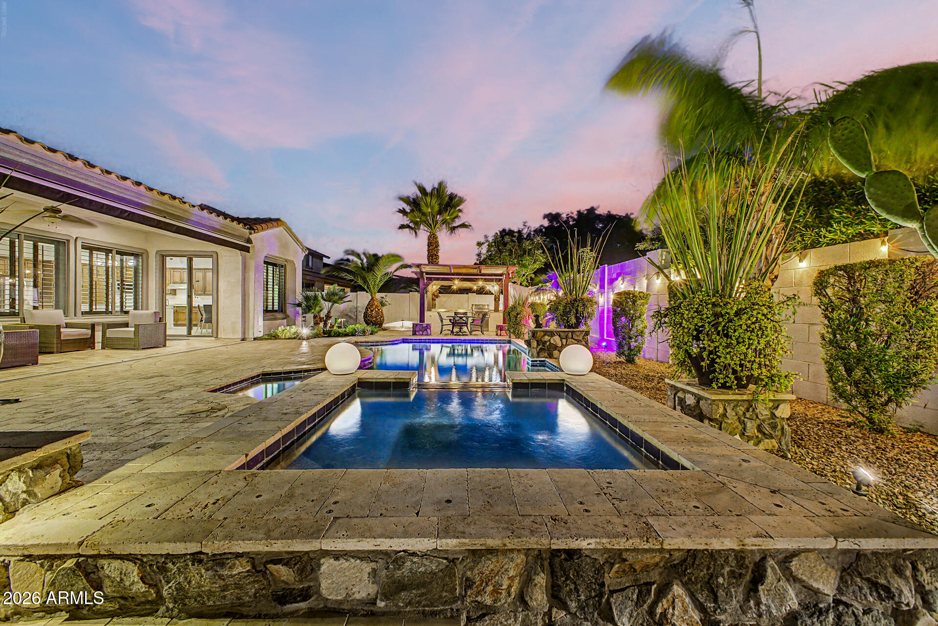 Experience RESORT-STYLE living in this stunning home w/POOL & SPA! Located in the Village at Litchfield Park, this remodeled single level beauty with center courtyard offers 3508 SF, 4 beds, 3.5 baths, great curb appeal, mature desert landscape plus 3-car garage. Interior exudes elegance with a welcoming foyer, wood shutters, tall 10' ceilings, archways, abundant natural light, neutral paint & wood-look tile floors everywhere except secondary bedrooms  Custom shutters & remodeled bathrooms with newer tiled showers. Excellent floor plan showcasing formal living & dining room alongside an open-concept family room w/a fireplace. Gourmet kitchen boasts SS appliances with double ovens, quartz counters, tiled backsplash and large island w/bfast bar. Fully owned solar too for low electric bills! The lavish primary bedroom includes two vanities with quartz countertops, a make-up vanity, & two walk-in closets. Luxurious tiled walk in shower too. One private secondary bedroom with its own walk in closet and bathroom, perfect for the guests. You'll love the center courtyard with a Pergola, pavers, & a gas fireplace! Designed for ultimate relaxation and entertainment, the spacious backyard oasis impresses you with a covered patio, well-laid travertine, sparkling pool & spa, and a built-in BBQ grill under the pergola. Plus SOLAR PANELS that are fully owned for low electric bills!! What's not to like? This gem is a dream come true!