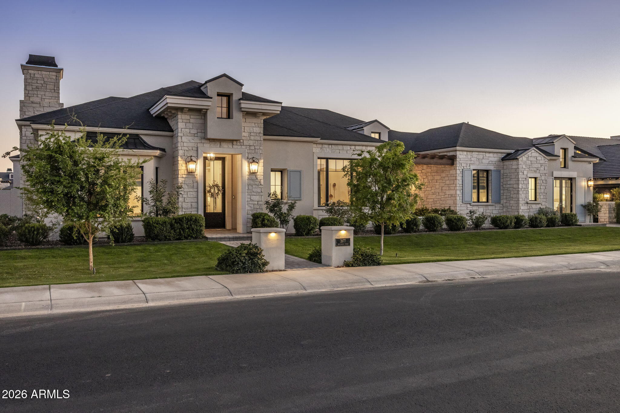 Experience refined luxury in this custom estate within Gilbert's gated Landmark at Somerset. 4,731 sq ft of light-filled living showcases expansive Windsor sliding glass walls, rich hardwood floors, and a chef's kitchen featuring a Wolf range, dual refrigerator/freezer, farmhouse sink, and butler's pantry. The thoughtful split floor plan offers 4 bedrooms and 4.5 baths, with a luxurious primary suite retreat featuring a soaking tub and separate shower. Designed for effortless entertaining, the home opens to more than 1,500 sq ft of covered outdoor living with travertine patios, outdoor kitchen, resort-style pool, and firepit. Includes a separate family room and optional exercise room for additional living. A private auto court and four-car garage complete this exceptional offering.