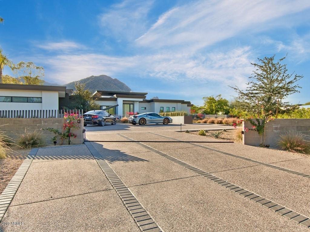 INCREDIBLE GORGEOUS HOME WITH IMPECABLE CAMELBACK MTN AND PRAYING MONK VIEWS!  4 BED, 4 FULL BATH AND 2 POWDER ROOMS IN THE MAIN HOUSE ALONG WITH A 2 BED, 2 BATH GUEST HOUSE.  HIGH-END CONTEMPORARY FINISHINGS THROUGHOUT THE HOME. LARGE GREAT ROOM WITH BUILT-IN ELECTRIC FIREPLACE AND POCKET DOORS THAT OPEN UP ALL THE WAY TO THE PATIO AREA. AN SEPARATE OFFICE, WORKOUT ROOM, THEATER ROOM AND BONUS AREA. GUEST HOUSE HAS ITS OWN LIVING AND KITCHEN AREAS TOO. AN ENTERTAINERS PARADISE IN THE BACKYARD WITH PRIVATE POOL, SPA, GAZEBO, BUILT-IN BBQ, SEATING AREA, FIRETABLE. HOME IS SURROUNDED BY  GORGEOUS LUSH GRASS AND DESERT LANDSCAPING. THIS ESTATE IS FIRST CLASS ALL THE WAY!