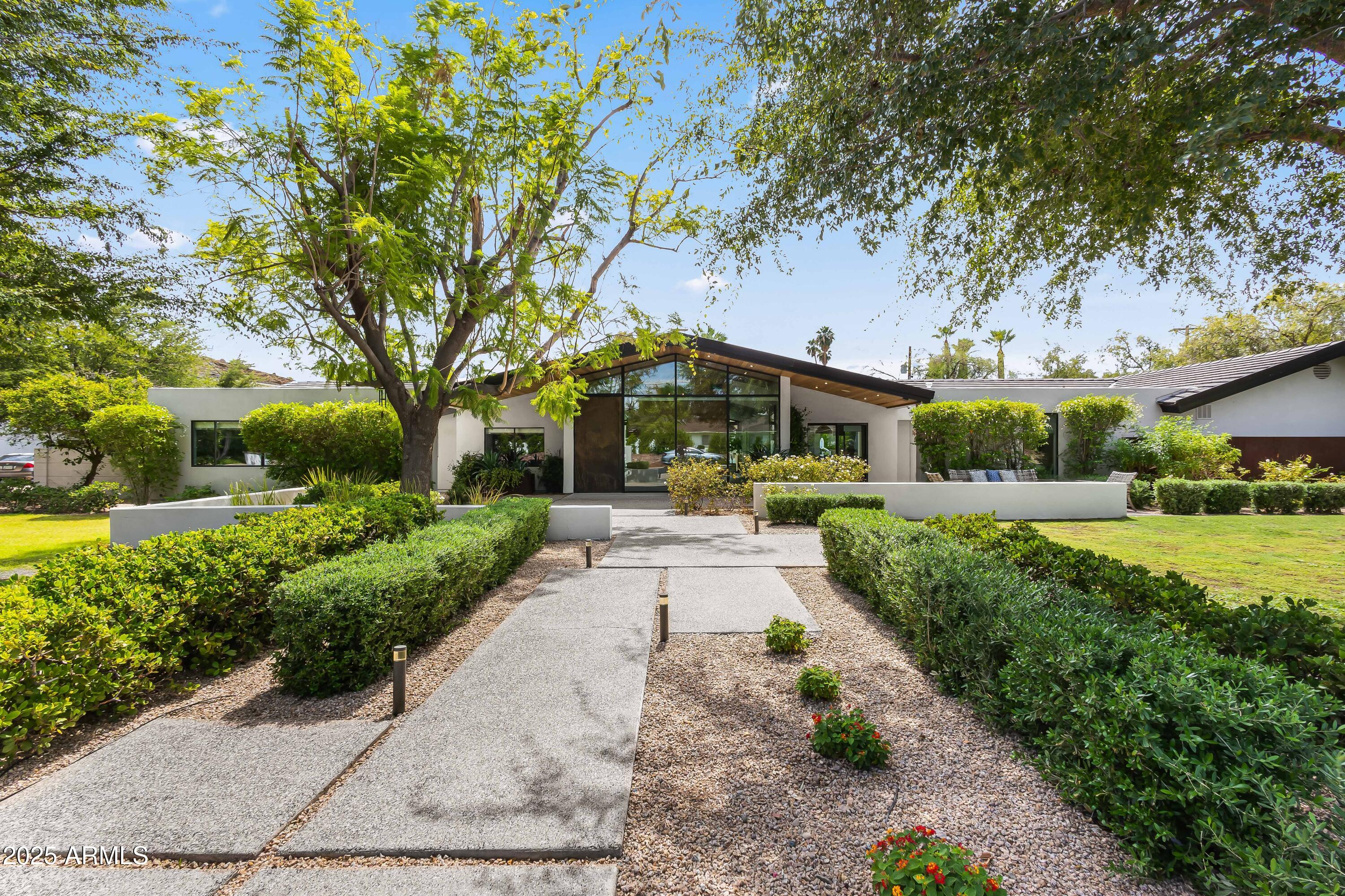 Located in the coveted Hopi School District, this stunning Arcadia home is perfectly positioned on a quiet and desirable stretch of Exeter, one of the neighborhood's most iconic and prestigious streets. Nestled on a rare half-acre lot in Arcadia Proper, this meticulously maintained, turn-key property represents an incredible value. Rarely does a home of this size, quality, and location come to market at this price point.  Thoughtfully designed for modern living and effortless entertaining, the home offers seamless indoor/outdoor flow with expansive sliding doors that open to multiple private patios and breathtaking Camelback Mountain views. The outdoor spaces feature a heated pool with newly refinished Kool decking, expansive entertaining areas, artificial turf, a built-in BBQ, and a sport court, all centered around a spacious covered patio ideal for gathering with family and friends. Inside, the chef's kitchen is a true standout, boasting two 14-foot islands topped with honed marble, a full back kitchen, paneled Thermador refrigerator and freezer, Miele ovens, a built-in espresso maker, and dual dishwashersperfect for both everyday use and hosting on a grand scale. The floor plan is very functional including a luxurious primary suite, four generously sized guest suites, and a versatile flex space with direct access to the backyard, offering true indoor/outdoor living. The home has been meticulously cared for, with thoughtful updates that include a newer roof and HVAC systems. Additional features include a Control4 home automation system, whole-house water filtration, air cleaners, generous interior storage, and a spacious three-car side-entry garage with built-in cabinetry.  Blending timeless Arcadia charm with modern amenities and top-tier finishes, this home delivers the perfect combination of comfort, style, and functionality in one of the most desirable locations in all of Phoenix.