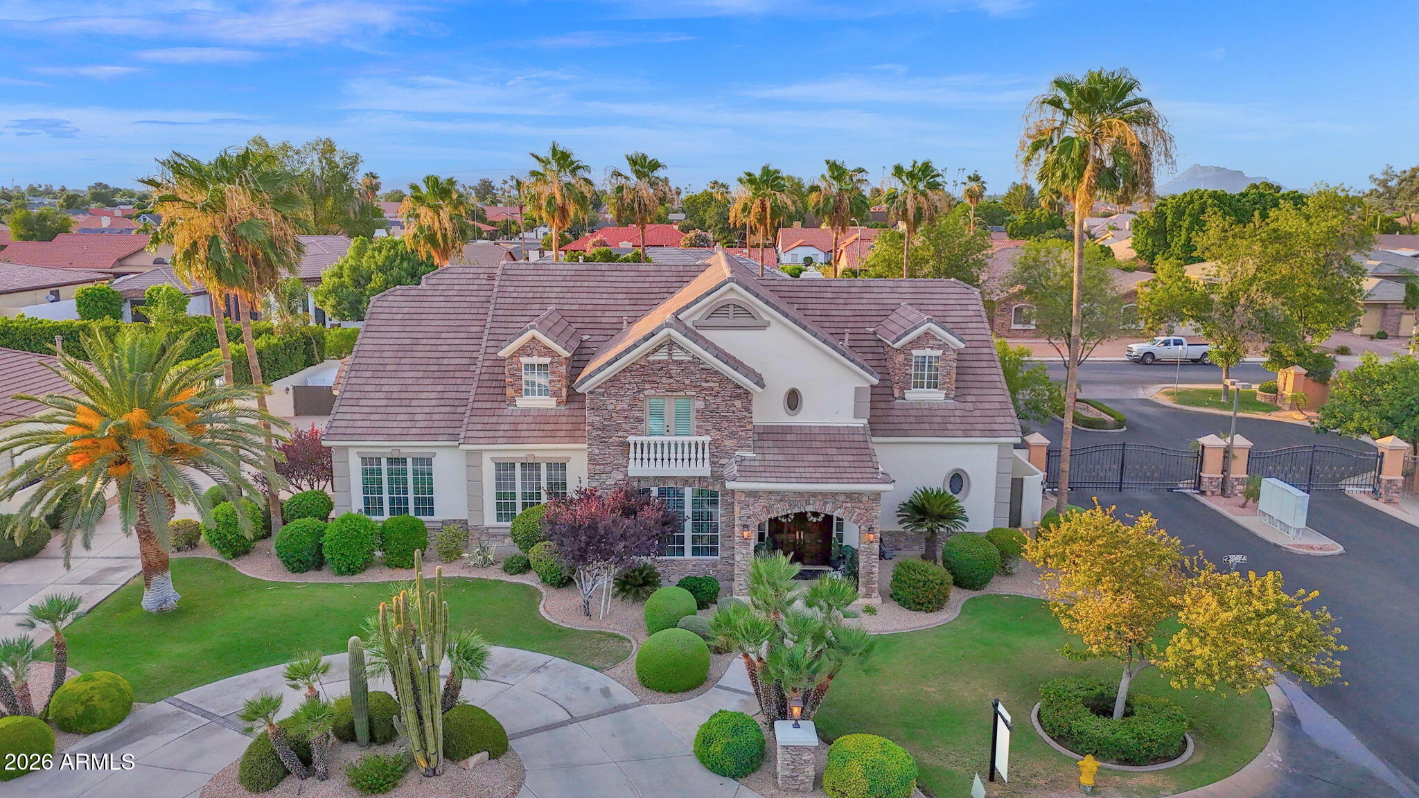 Custom built French Country estate in the gated Hidden Groves community. Stunning 6 BD / 4 BA, 5,862 sq. ft. on a private 0.4 acre lot. A circular driveway leads to a travertine covered front porch and grand entry with real hardwood tongue and groove plank flooring. Formal living and dining rooms flank the foyer and kitchen. A dramatic family room features 20-foot ceilings, travertine floors, a gas fireplace with custom mantle, built-in cabinetry (TV conveys) and panoramic views to the resort style backyard.
Remodeled kitchen (2 years) offers updated countertops and sink, Thermador counter depth refrigerator, double ovens, gas cooktop, ice maker, trash compactor, added cabinetry and walk in pantry. Main floor primary suite has dual closets and a jetted tub; an additional main floor bedroom has a private entrance and full bath. Upper level is carpeted and includes a home theater, bonus/party room, four bedrooms, two full baths and a storage room.
Outdoor living is exceptional. Extended travertine covered patio (1 year), Kiln Fired Adobe pool deck, diving depth pool with rock slide, waterfall and in ground spa, outdoor kitchen/BBQ area, and shower. Mature citrus trees, block and stucco perimeter walls with decorative rock and coach lights create a private, entertainer ready setting.
Additional highlights: 3 car extended garage with built ins, automatic RV gate with concrete pad, Electrolux central vacuum, two tankless water heaters, owned water softener, electronic/app based pool and landscape controls, wired Ring exterior cameras convey, under stair storage roomy enough for extra refrigerator/freezer, laundry with fold out ironing board, plantation shutters, full home intercom system. Home painted inside and out 1.5 years ago. Neighborhood amenities include lighted tennis, pickleball, and basketball courts, as well as a picnic and children's play area. A rare, turnkey French Country estate in a premier gated neighborhood.