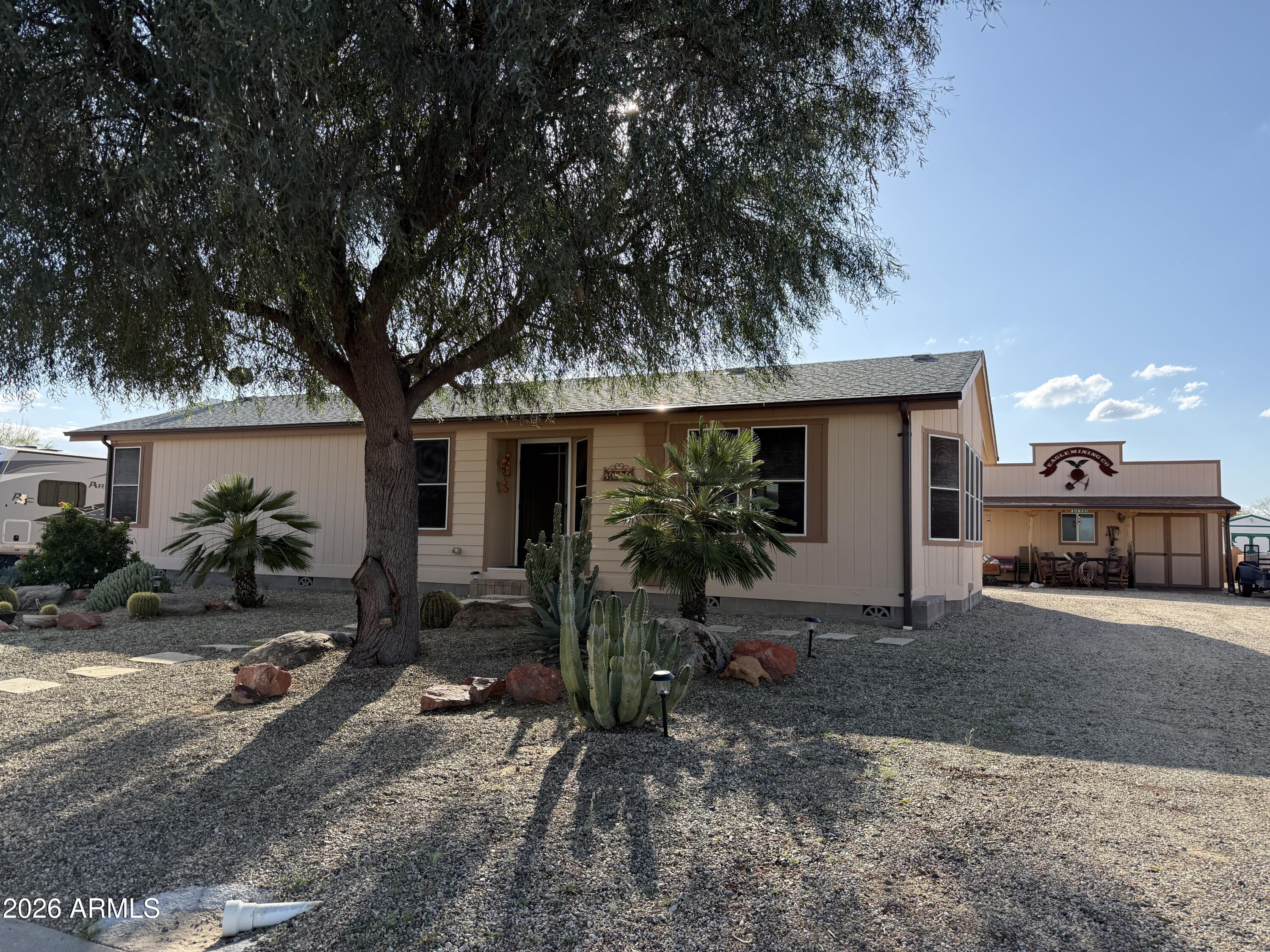 One Owner Custom Property- a Durango at 30970 S Vagabond Trail: An ENERGY STAR manufactured home, nicely furnished, ~1,386 sq ft, 1 bed + 2 PLUS  rooms(Office & Guest Room), 2 baths, Low-E windows, new flooring, walk-in closet, step-in shower.24x28 Western-style shop/garage steals the show: sealed slab floor, insulated and sheet rocked, plus 220 welding setup and two Car garage. Another Bonus 12x24 Western-style shop with sink, plumbed for W/D, slab foundation, fridge, and water heater. Two RV hookups (one back, one side).   Public land on two sides and entry is just feet away! Open the gate to miles of ATVing and Hiking Trails. The Clubhouse offers a multitude of interesting crafts, get together and even ice cream socials. Located between Congress & Wickenburg
This Property is a Must See