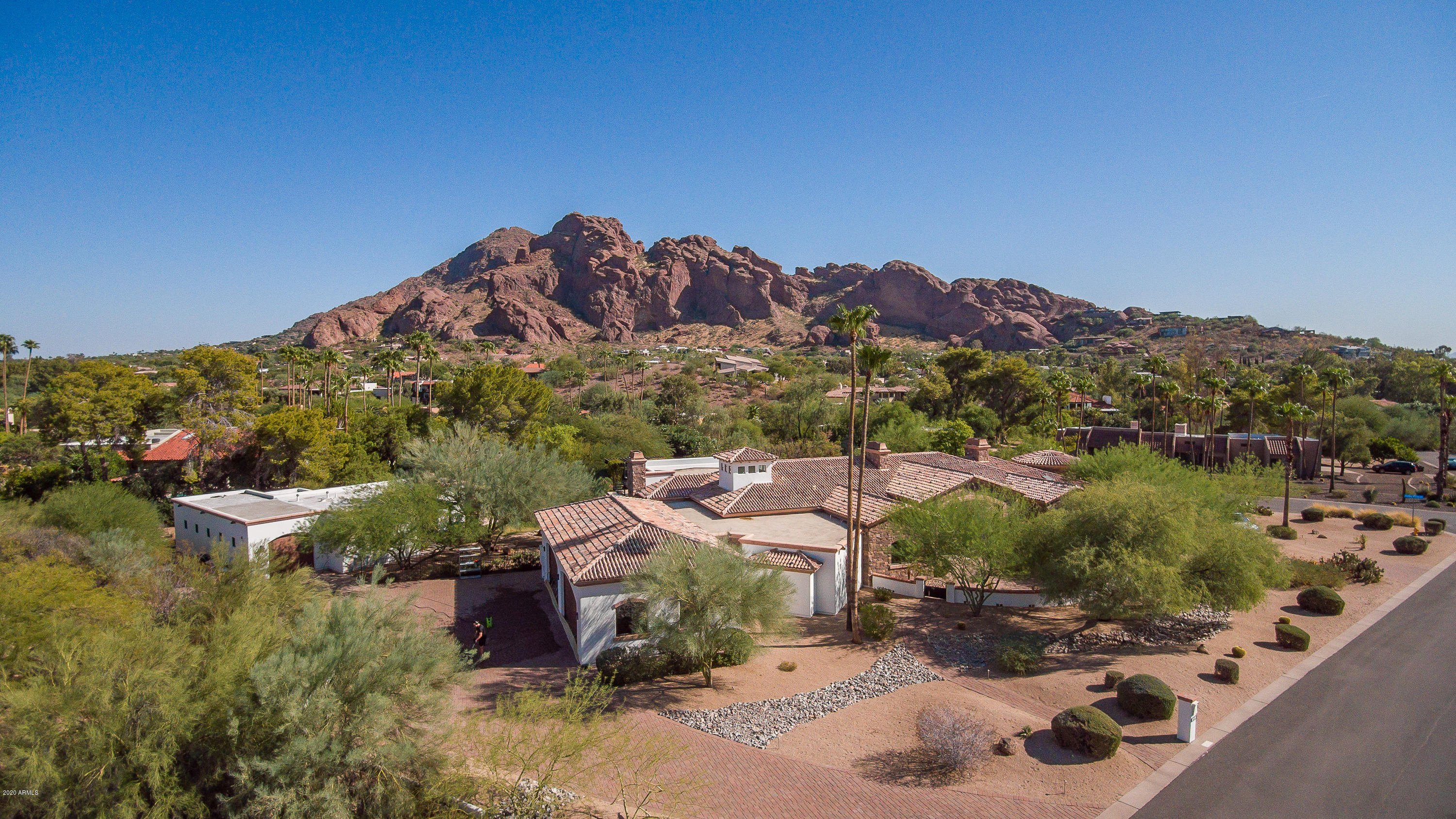 Views Views Views Welcome home to this amazing single level custom built estate nestled 600ft from majestic Camelback Mt.  New construction in 2008 includes large chefs kitchen with double islands, two prep sinks, commercial size refrigerator, all Electrolux & Thermador appliances.  Do yoga or workout in your private bonus 1000sf gym space that can be used as a flex room for the hobby, boating, or car enthusiast.  The 4,746sf main house includes 4 bedrooms, home theater, and grand owners retreat with 16ft high  rotunda master bath shower/tub view with mountain views  .  Private 1,122sf detached guest house adds 2 more bedrooms for guests or a great private art or workspace.  Extra-large 4 car garage with Tesla charging station.  Outside multiple gas fire features with large covered and uncovered patio space for entertaining large groups.  Looking for an even better view?  Go upstairs to the view deck to relax and take in the view-set up for hot tub placement with water and power.  Energy efficient home with spray foam insulation including sound proofing around home theater