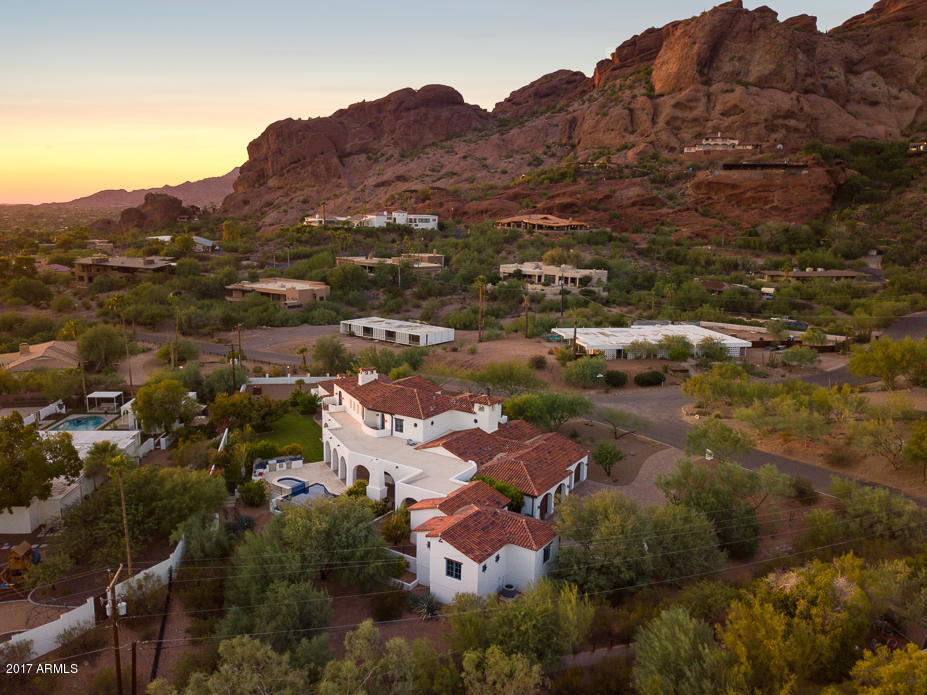 LUXURY / WARMTH / FUNCTION are the hallmarks of this Beautiful Spanish Colonial HOME; built from the ground up in 2010. With a regal presence situated on the south side of Camelback Mtn, this ONE OF A KIND home combines an elevated caliber of construction & pristine architecture with magnificent downtown Phoenix & Camelback Mountain views. The 7,077 SF Main house offers 4 EnSuite Bedrooms with a downstairs Master Retreat & 6.5 baths, a bright airy living room open to the elegant rustic kitchen, an exquisite dining room, a casual media /game room w/ hand finished built ins, an office, library and meditation room. 
Everywhere you look, you know this is a special property - from the hand distressed hardwood hickory floors to the custom chandeliers and artisan tile, beautifully curated from.. ...every corner of the world specifically for this home.
The 1,105 SF fully self-contained guest house has two bedroom and one oversized custom finished bath, a separate entrance and a full kitchen and laundry. This would be a perfect MIL, au pair, or guest residence.
Love the interior but then step outside and be astonished by the exterior with 360 degree views of Camelback Mountain, Papago Buttes, and the Downtown Phoenix skyline. Full length covered terraces invite you to enjoy the fireplace, out door kitchen featuring a green egg, cerulean blue tiled infinity pool and raised spa, and plenty of lush green grass and landscape. Truly a one of a kind!



ADDITIONAL INFORMATION:
 -    Designed by Robert Brown of Montgomery Design Group
-	The home sits on .97 of an acre
-	Circular drive in front
-	Front courtyard entry with a fountain and an Isokern fireplace
-	Four car side entry garage has 9' entries, additional storage and epoxy flooring
-	Construction is 2x6 throughout & 2 x 12 and 2 x 24 along some exterior walls to allow the deep set window wells typical of this stye architecture.
-	Architectural features include: mud set tile roof, iron gratings, window lintels where appropriate, a bell tower with weathervane (also acts as a lightening rod), copper flashing and scuppers.
-	Doors and windows are by Sierra Pacific
-	Front entry door is arched alder with multiple panes of translucent glass
-	Interior floors are solid hickory hardwood
-	Family room fireplace is by Isokern with a canterra stone surround
-	Staircase has custom wrought iron railings and hickory treads, upstairs railing heights are higher than code for added safety
-	Staircase tile risers are from Ann Sacks â“ Antique Parefeuille Terracotta
-	Ceiling feature center cut solid wood beams
-	Wine Room with a 540 +/- capacity and dual zone temperature control
KITCHEN
-	Wolf 48", 6 burner stove w/ griddle and 2 ovens
-	Wolf wall oven
-	Wolf microwave
-	Two Asko dishwashers
-	Side-by-side SubZero fridge and freezer drawers
-	SubZero ice maker
-	Perimeter cabinets are off white stained alder with black honed granite counters
-	Custom furniture island is knotty alder with hand painted red Mexican tiles
-	Talavera tile backsplash
-	Pot filler
-	Oversized wrought iron island chandelier
-	Large walk-in pantry and butlers pantry
-	Kitchen flooring is reclaimed French roof tiles
DINING ROOM
-	Double French doors open to the front courtyard
-	Pitched ceiling with center cut solid wood beams
-	Large chandelier from Italy
MEDIA ROOM
-	Built in entertainment center accommodates a 64" TV
-	Wet bar with a pewter sink
-	SubZero mini fridge
-	Alder cabinets with a special locking liquor cabinet
-	Flooring is De Golpe Manganese Saltillo
-	Whimsical hand painted Mexican tile adorns the wet bar
-	Full bath off the media room  has direct pool access.
MASTER SUITE
-	Groin vaulted ceiling treatment in the vestibule
-	Isokern fireplace
-	Center cut solid wood beam ceiling
-	French doors to the covered terrace
-	Wterworks Carrera marble tile with limestone insets in the luxurious His / Her bath
-	Calista free standing tub
-	Concealed safe
-	His and Her closets with extensive solid wood built-ins
LIBRARY
-	Fully paneled in alder wood
-	Coffered ceiling
-	Library ladder
-	Built in file drawers and printer cabinets
-	Private balcony with downtown Phoenix views
EXTERIOR
-	Negative edge pool with hand painted porcelain tile.
-	Heated pool and spa
-	Salt water pool
-	Pool decking is Marbella stone
-	Ourdoor kitchen with a Big Green Egg
-	Four burner Lynx grill
-	Lynx fridge
MECHANICAL
-	The main house has underground returns and a total of 17 tons of AC, all 14 SEER: 2 5 ton Lennox units with gas furnaces, 1 2 ton Lennox unit with a gas furnace, 1 5 ton heat pump.
-	Guest house is services by a 3 ton Lennox heat pump
-	6 amp service
-	Cat 5 wiring throughout with multiple places to add media
-	Power lines have been buried on the property
-	75 gallon hot water heater and 3 tankless hot water heaters
-	Toto toilets throughout
-	Extra insulation throughout
-	Extra wide joists and subflooring and insulation on second floor for sound control