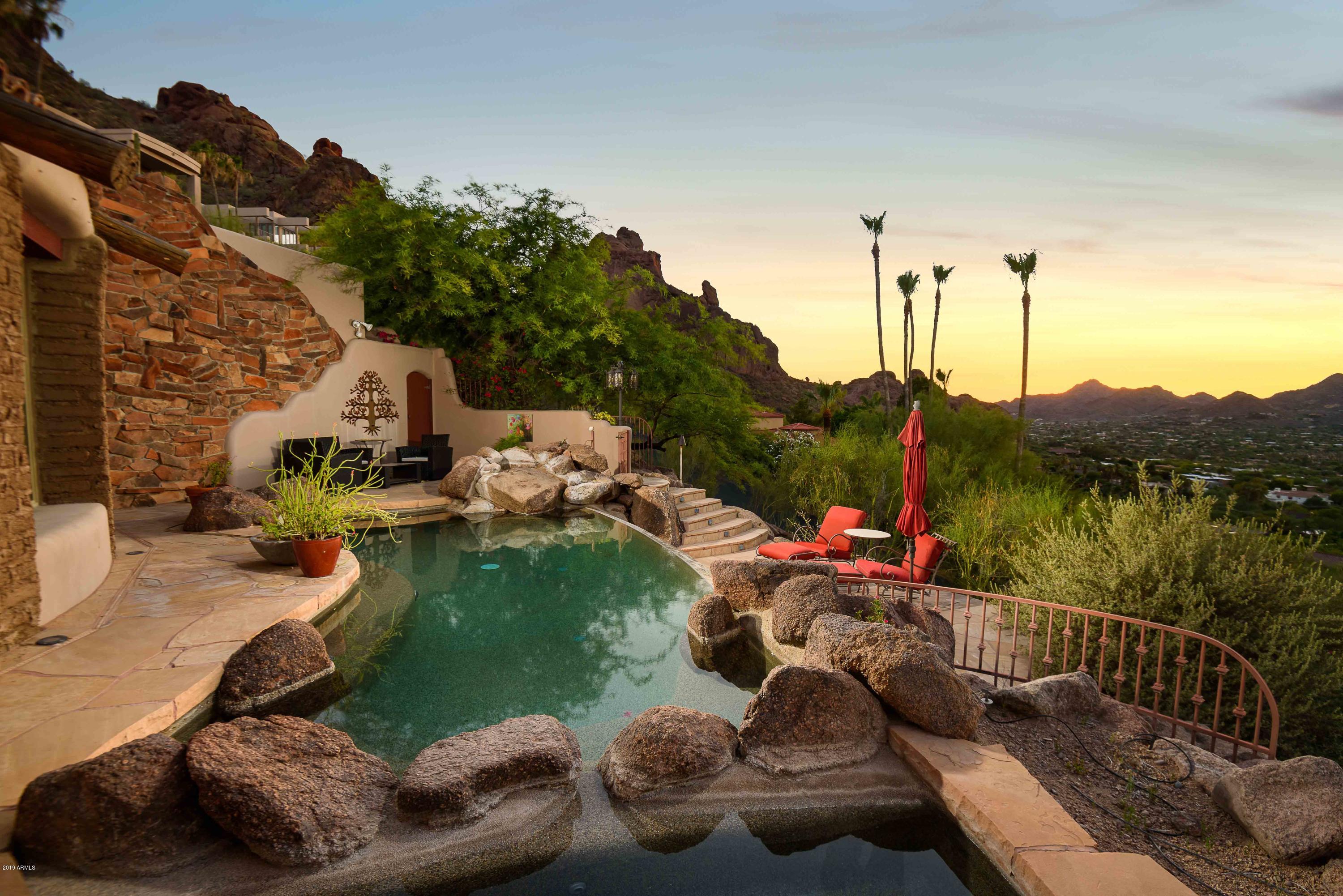 BEST VIEWS IN ALL OF PARADISE VALLEY. Perched high atop Camelback Mountain, this fabulous, privately double gated, 1.44 Acre Custom Estate enjoys commanding views of the Praying Monk, Mummy Mountain, Piestewa Peak, and Paradise Valley in all of its lush rejuvenated splendor! Old World Charm with Quality Construction, tongue & groove ceilings, vigas and latillas. Master Suite includes a fabulous office and views from every window. ENTERTAINER'S DREAM with a negative edge pool, spa and covered patio with gas fireplace, extended sitting area for all-encompassing views. A relaxing waterfall descends down Camelback Mountain, with the property borders ascending to ensure privacy from above.