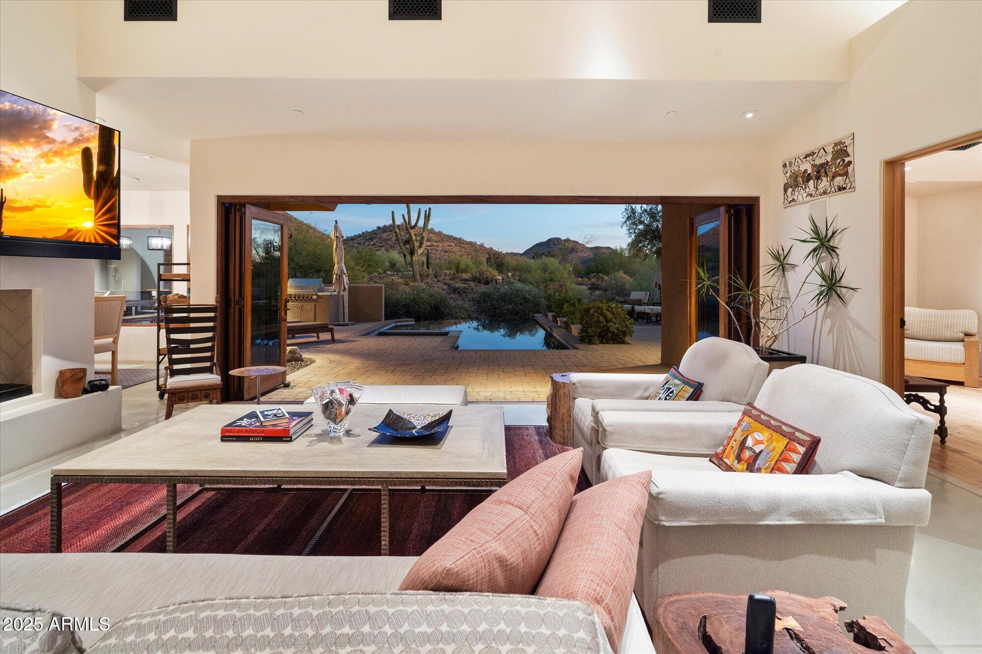 Welcome to this one-of-one serene sanctuary, designed by Taliesin-trained architects Yumi Doi and Gustad Irani; inspired by the Japanese concept of Shibumi. Nestled on 3.33 acres of pristine Sonoran Desert south of Pinnacle Peak with breathtaking mountain and city lights views, this LEED-certified, single-level home features 4 en-suite bedrooms each with private patios and dual entry points, as well as a detached guest house complete with kitchen, living room, bedroom, walk-in closet, laundry, private courtyard and patio. Additionally there is a library, an office/potential 5th bedroom, and 2 additional half baths. The kitchen features top of the line appliances such as Wolff gas range, Miele steam oven/warming drawer, Subzero refrigerator, wine cooler, ice maker and custom cabinetry. The climate-controlled 4 car garages have built in cabinets and closets for extra storage. Tranquil outdoor spaces crafted by Taliesin's original landscape architect, Joan Brooking. Featuring an abundance of natural light from clerestory windows, seamless flow and privacy, use of thematic arches, natural building materials, and principles of Feng Shui, this home embodies tranquility, elegance, and timeless design. Must experience this property to appreciate the peacefulness of the home and the luxury in the attention to detail.
