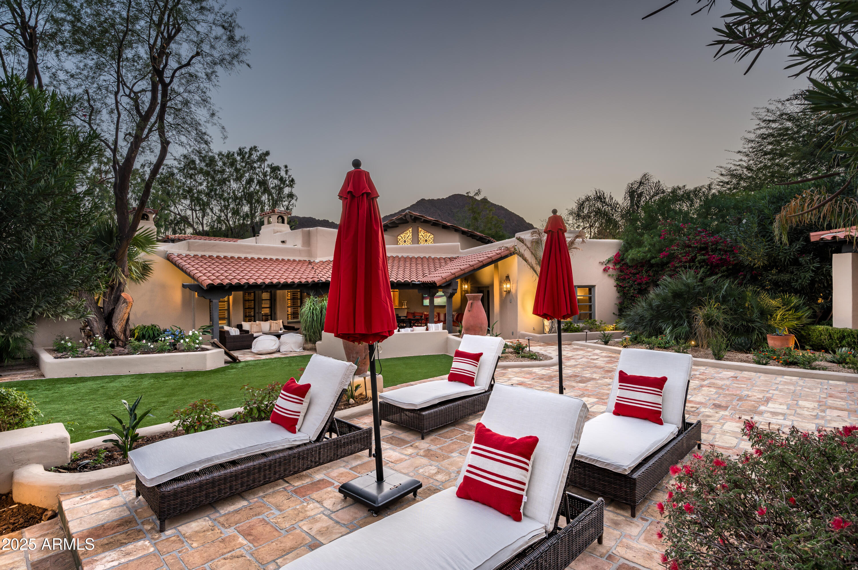 A Timeless Masterpiece in the Heart of Paradise Valley!
Tucked away at the base of Camelback Mountain, this one-of-a-kind estate captures the essence of Arizona living with a bold embrace of authentic Southwest design. Thoughtfully crafted by Lash McDaniel, a Phoenix Home & Garden Master of the Southwest, and built with precision by Kitchell, every inch of this stunning residence tells a story of artistry, heritage, and intention. Classic stucco walls, red tile roofing, and hand-carved wood details create a striking first impression. A winding Saltillo-tile path and private wooden gate lead to a lush, fountain-adorned courtyard setting the tone for the tranquil, transportive experience that lies beyond. Inside, you'll find curated textures and custom elements at every turn from reclaimed French roof tile flooring and ornate ironwork to dramatic vaulted ceilings and archways. A hexagonal entry with soaring ceilings gives way to the sun-filled great room, where clerestory windows, hand-carved saguaro rib shutters, and a grand stone fireplace establish a warm yet elevated ambiance. Seamless indoor-outdoor flow is enhanced by vintage screen doors and bespoke hardware that open to expansive covered patios.

Entertain with ease in the stunning chef's kitchen beneath a vaulted brick ceiling, where rustic beams frame clerestory windows and artisan stonework surrounds the custom range hood and fireplace. High-end appliances, a live-edge granite island with copper sink, and a butler's station with built-in Miele coffee maker elevate every culinary moment. Just off the kitchen, a generous laundry room and access to one of two 2-car garages make daily living effortless.

The owner's suite is a private sanctuary, marked by handcrafted wooden doors, serene sitting areas, and patio access that leads directly to the pool. The spa-like bath features radiant heated floors, an onyx soaking tub, and a peaceful courtyard with fountain and outdoor showeryour own private resort.

With multiple guest suites, a charming office with kiva fireplace, a detached fitness center, and a separate guest casita, this estate offers unparalleled flexibility. Entertain beneath the vaulted outdoor ramada with fireplace, grill, and dining space, or unwind beside the 75-foot saltwater lap pool accented by tiled spillways, sculptural agaves, and a watchful lion carved into the wall.

Set on a full acre, this property is both a peaceful retreat and a functional entertainer's dreamsurrounded by lush landscaping, citrus trees, tranquil walkways, and vibrant outdoor living spaces.

This is not just a homeit's a legacy. A timeless blend of strength, beauty, and soul in the very heart of Paradise Valley.