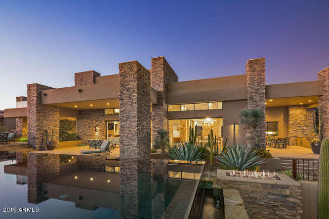 If I had to choose one word to describe this house it would be ''Sexy''. This desert contemporary home exemplifies the Mirabel lifestyle with casual elegance seamlessly blending the outdoor and indoor living spaces with multiple sets of automated pocket doors. It's being offered fully furnished and accessorized by a top interior designer. The backyard features an amazing raised, three sided negative edge pool, multiple fire features, a covered outdoor kitchen, private spa off the master bedroom and amazing golf course, mountains, city lights and sunset views- perfect for the buyers looking for the finest in architecture and the north Scottsdale lifestyle. The home has 6993 SF of livable space- 5 bedrooms, separate guest house, large wine room, media/game room upstairs and a 4 car garage